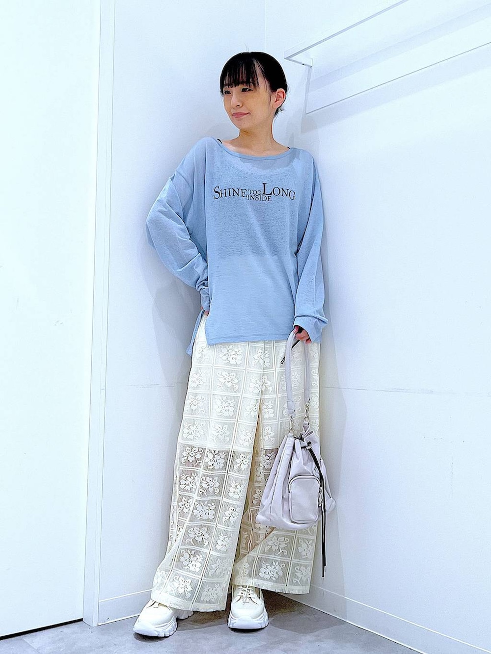 ブルー系のTシャツ/カットソー、ホワイト系のスニーカー、ホワイト系のショルダーバッグを着用したレディースの春コーディネートの2枚目の写真