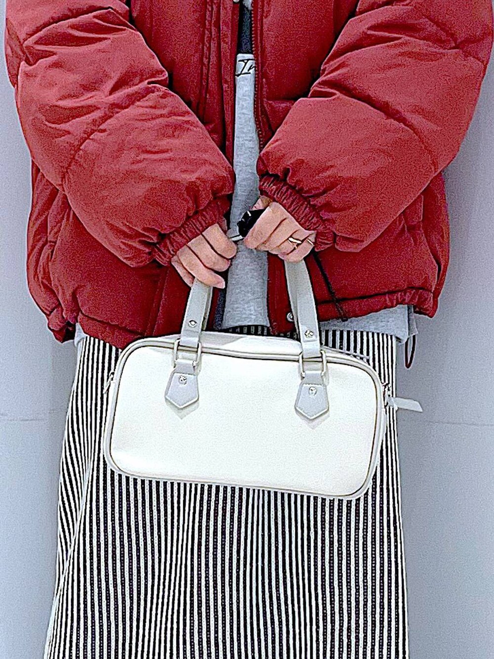 ブラウン系のブルゾン、ベージュ系のスカート、ブラック系のブーツを着用したレディースの冬コーディネートの9枚目の写真