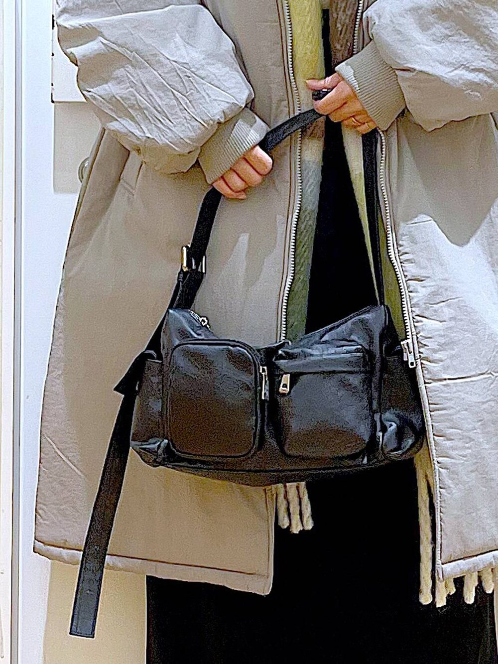 グレー系のミリタリージャケット、ブラック系のブーツ、ブラック系のショルダーバッグを着用したレディースの冬コーディネートの9枚目の写真