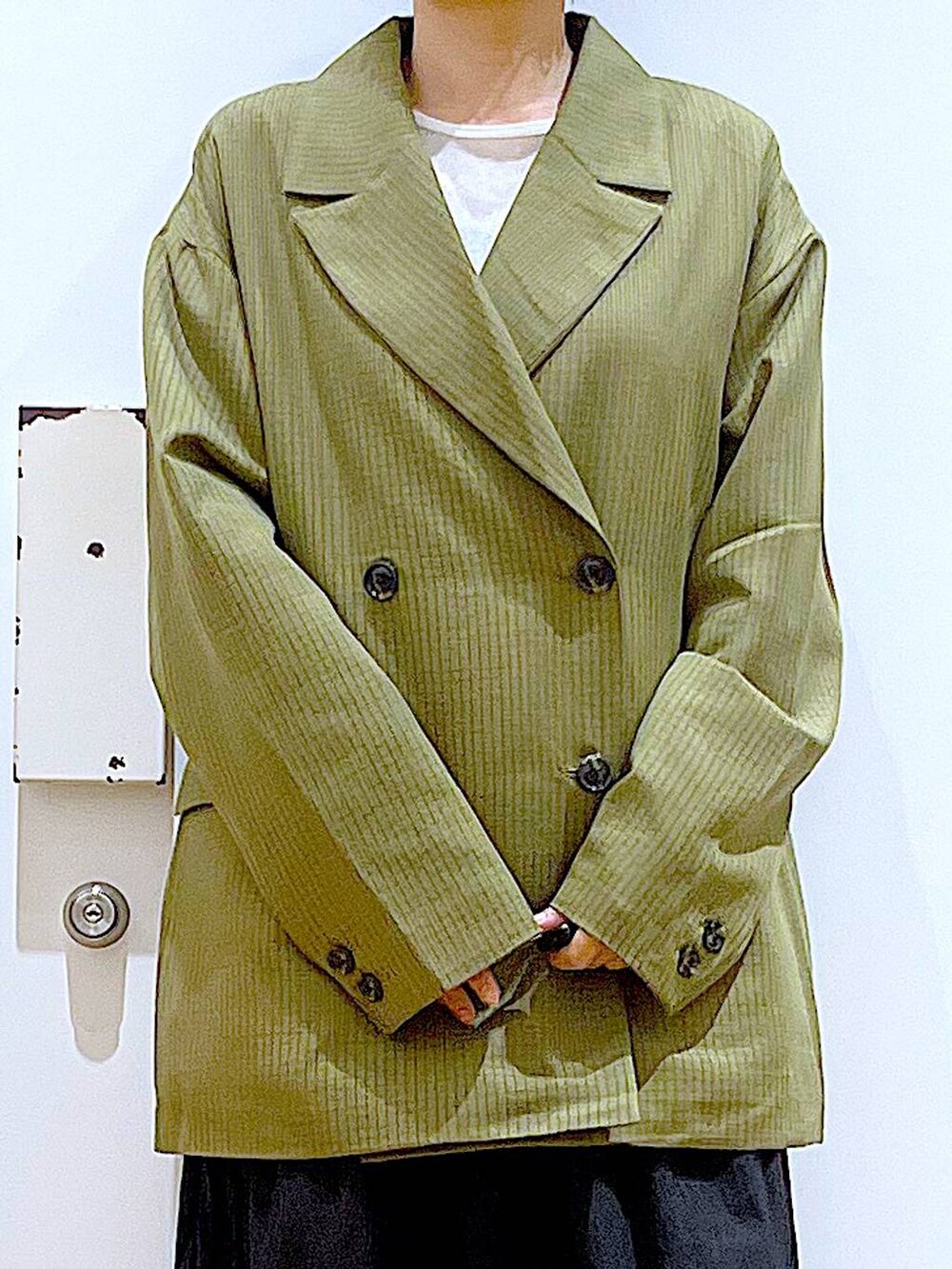 ブラック系のショルダーバッグ、ホワイト系のパンプス、ホワイト系のTシャツ/カットソーを着用したレディースの秋コーディネートの7枚目の写真