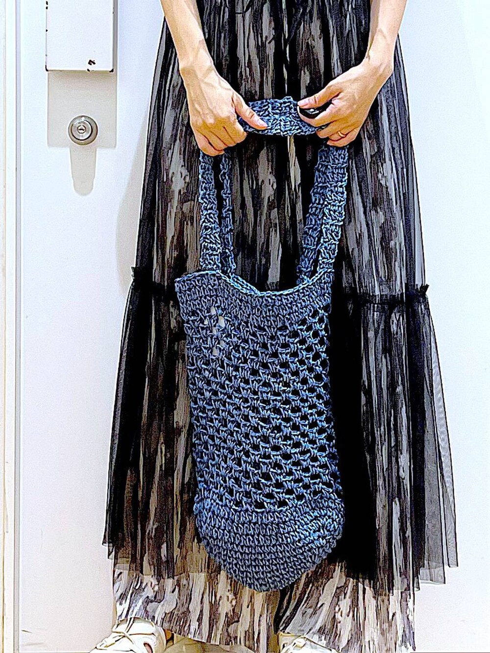 ブラック系のワンピース、ホワイト系のサンダル、ブルー系のトートバッグを着用したレディースの夏コーディネートの9枚目の写真