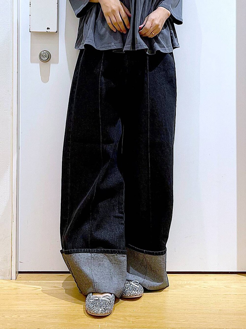 ブラック系のショルダーバッグ、シルバー系のパンプス、ブラック系のデニムパンツを着用したレディースの秋コーディネートの8枚目の写真