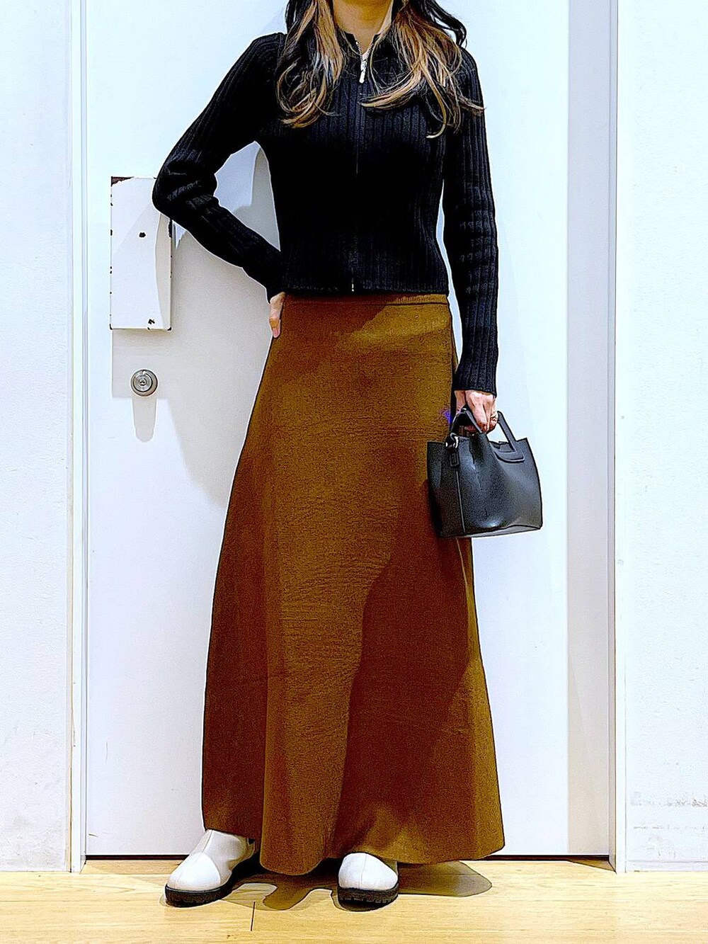 ブラック系のカーディガン/ボレロ、ブラウン系のスカート、ベージュ系のブーツを着用したレディースの冬コーディネートの6枚目の写真