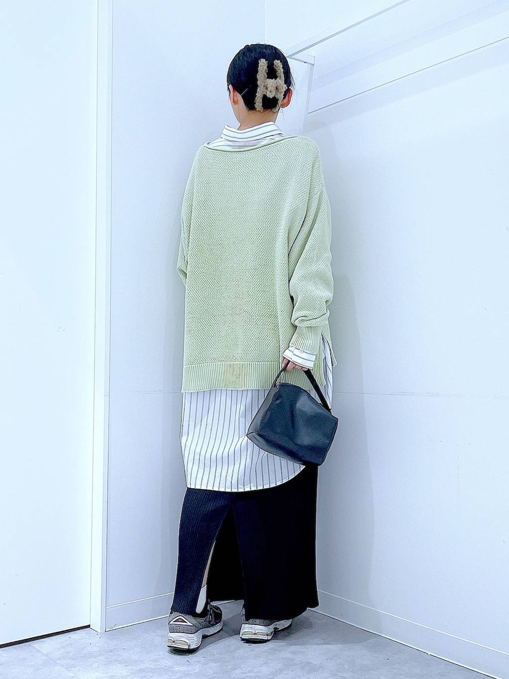 ブラック系のショルダーバッグ、ホワイト系のシャツ/ブラウス、グリーン系のニット/セーターを着用したレディースの春コーディネートの5枚目の写真