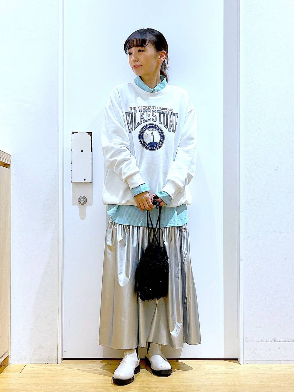 グリーン系のシャツ/ブラウス、シルバー系のスカート、ベージュ系のブーツを着用したレディースの春コーディネートの2枚目の写真