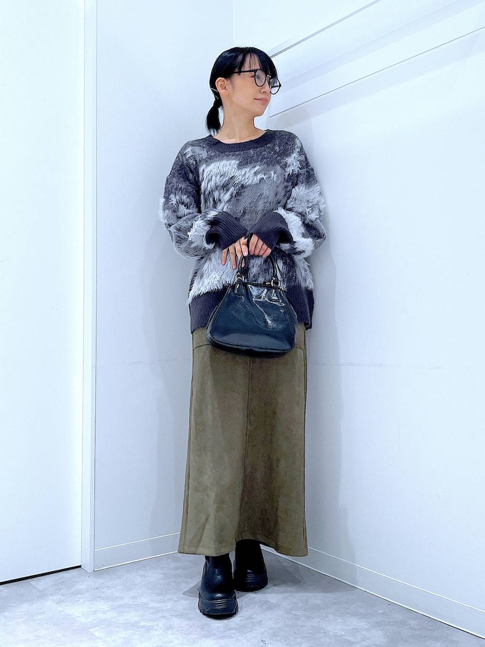 ブラック系のブーツ、ブラック系のニット/セーター、ブラック系のショルダーバッグを着用したレディースの冬コーディネートの2枚目の写真