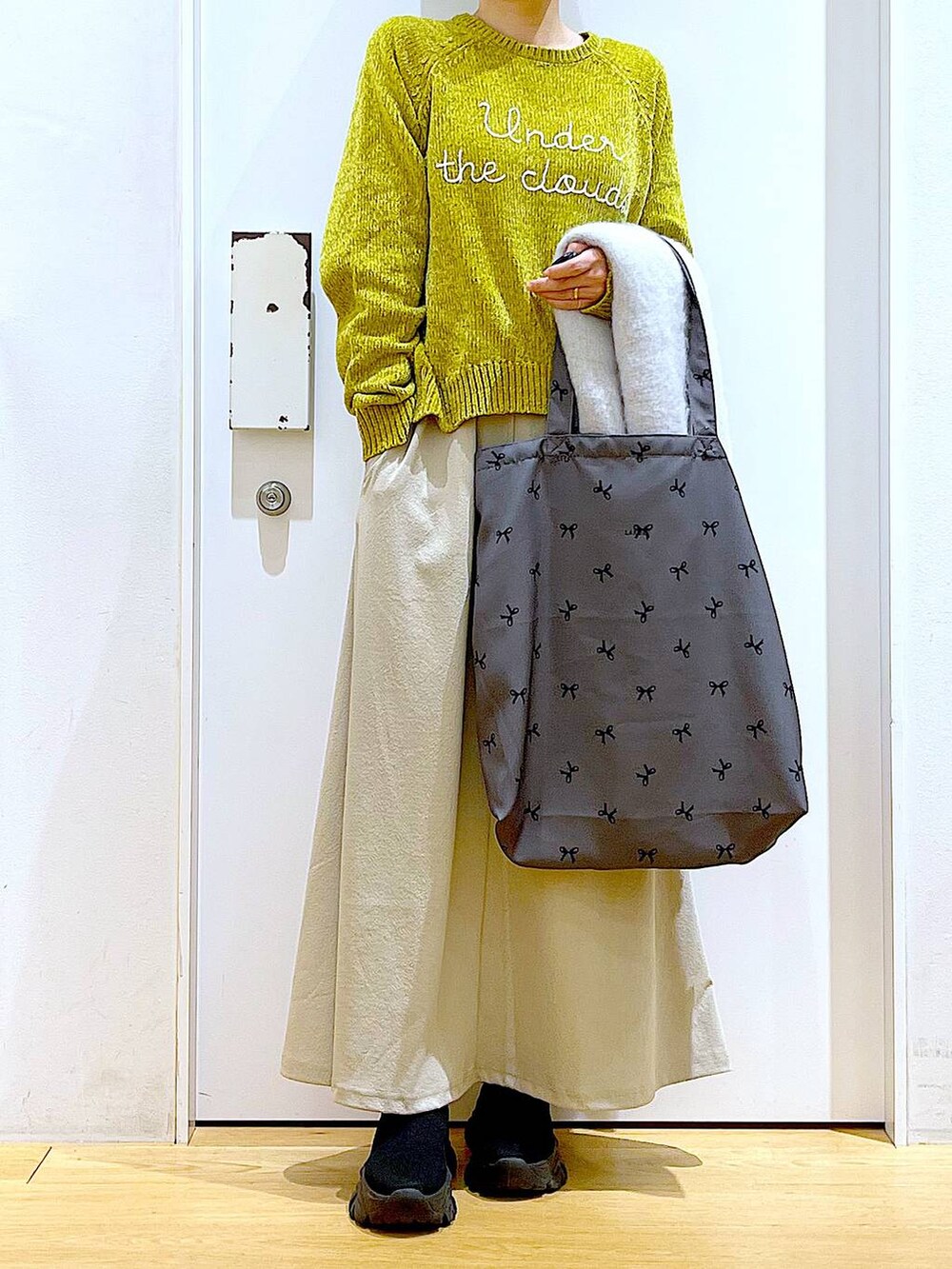 ブラック系のブーツ、その他のトートバッグ、グレー系のスカートを着用したレディースの冬コーディネートの6枚目の写真