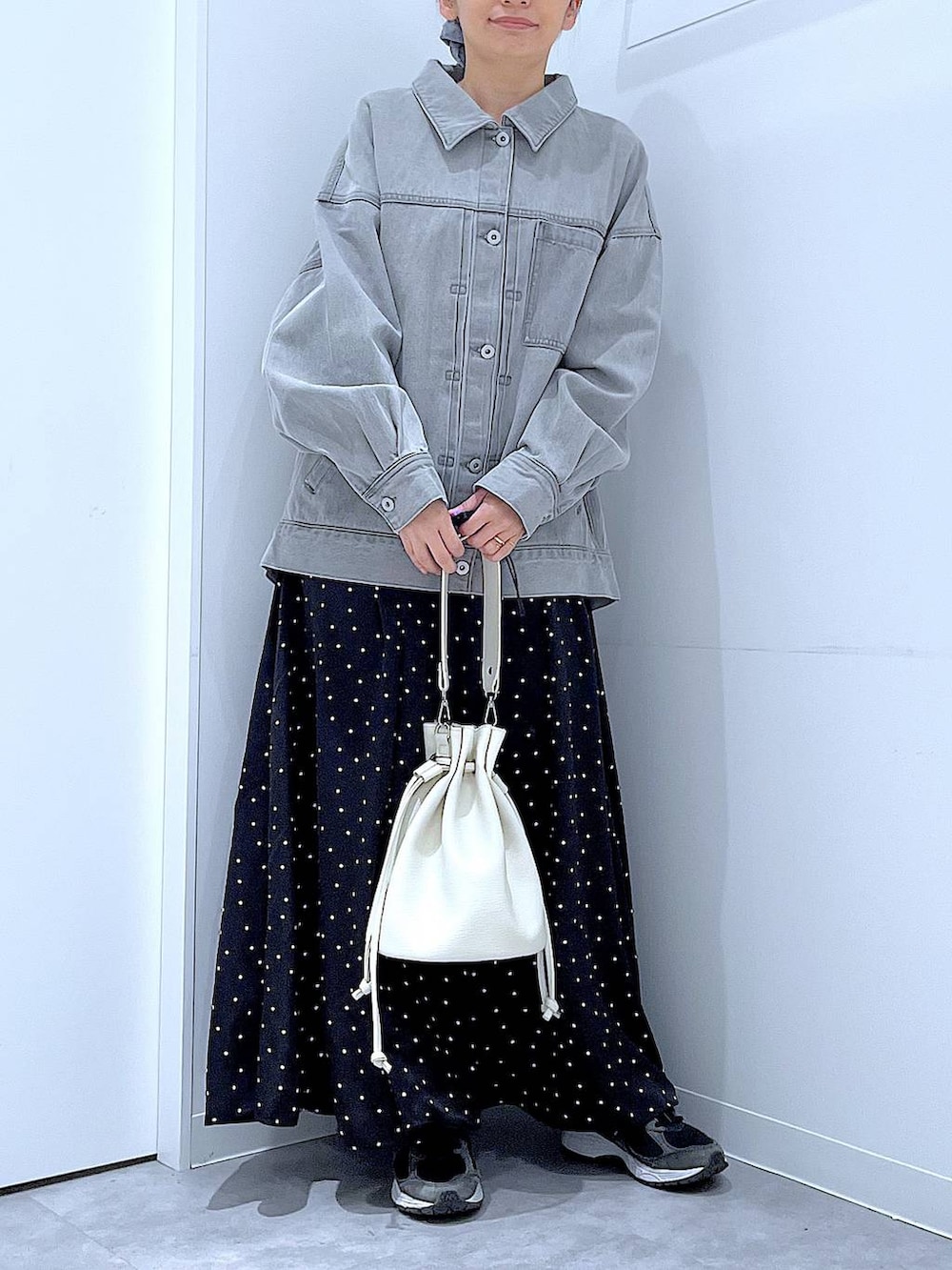 グレー系のデニムジャケット、ホワイト系のショルダーバッグ、グレー系のシュシュを着用したレディースの春コーディネートの6枚目の写真