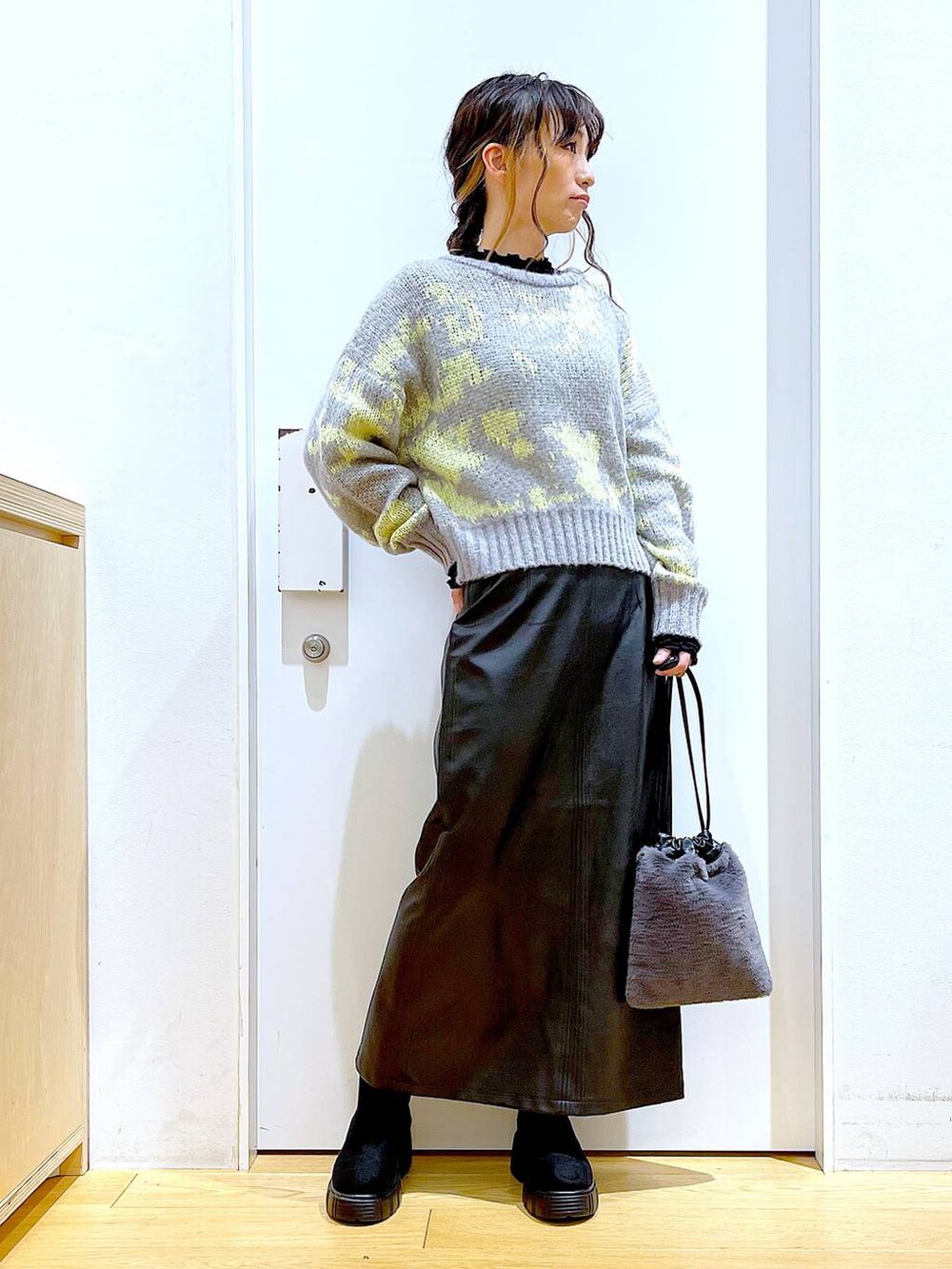 ブラック系のTシャツ/カットソー、グレー系のショルダーバッグ、ブラック系のブーツを着用したレディースの冬コーディネートの2枚目の写真