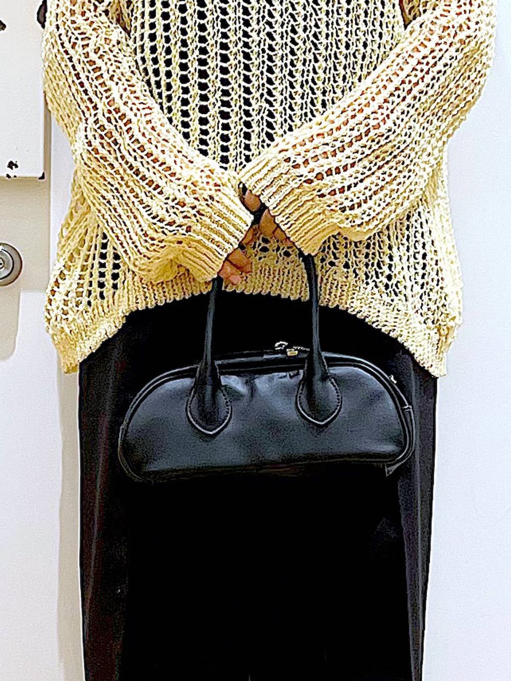 ブラック系のスラックス、ブラック系のボストンバッグ、ブラック系のパンプスを着用したレディースの夏コーディネートの9枚目の写真