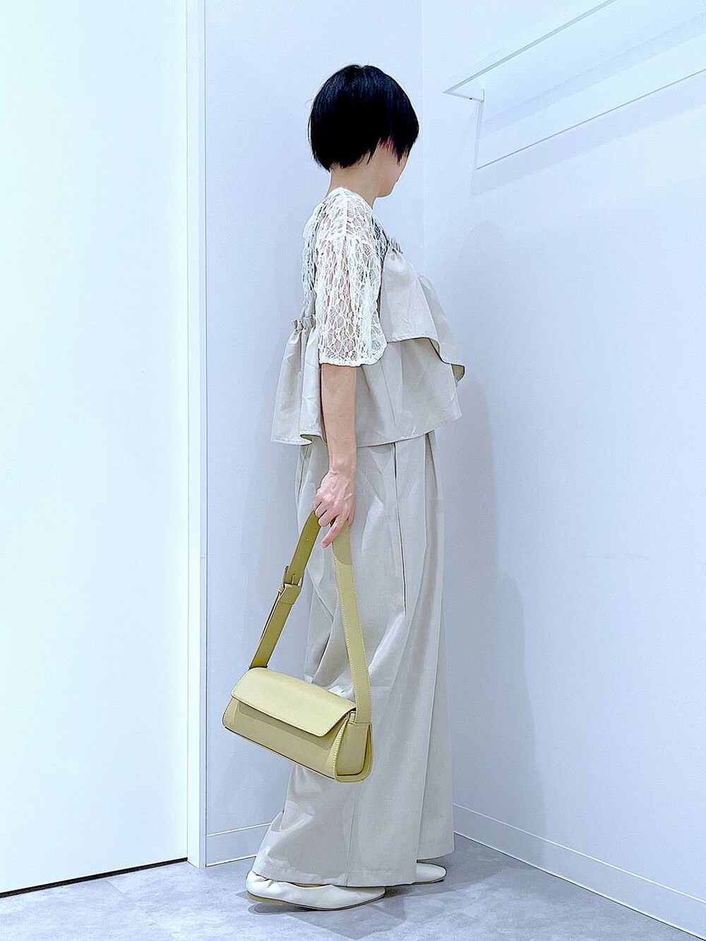 ホワイト系のパンプス、イエロー系のショルダーバッグ、ホワイト系のTシャツ/カットソーを着用したレディースの夏コーディネートの4枚目の写真