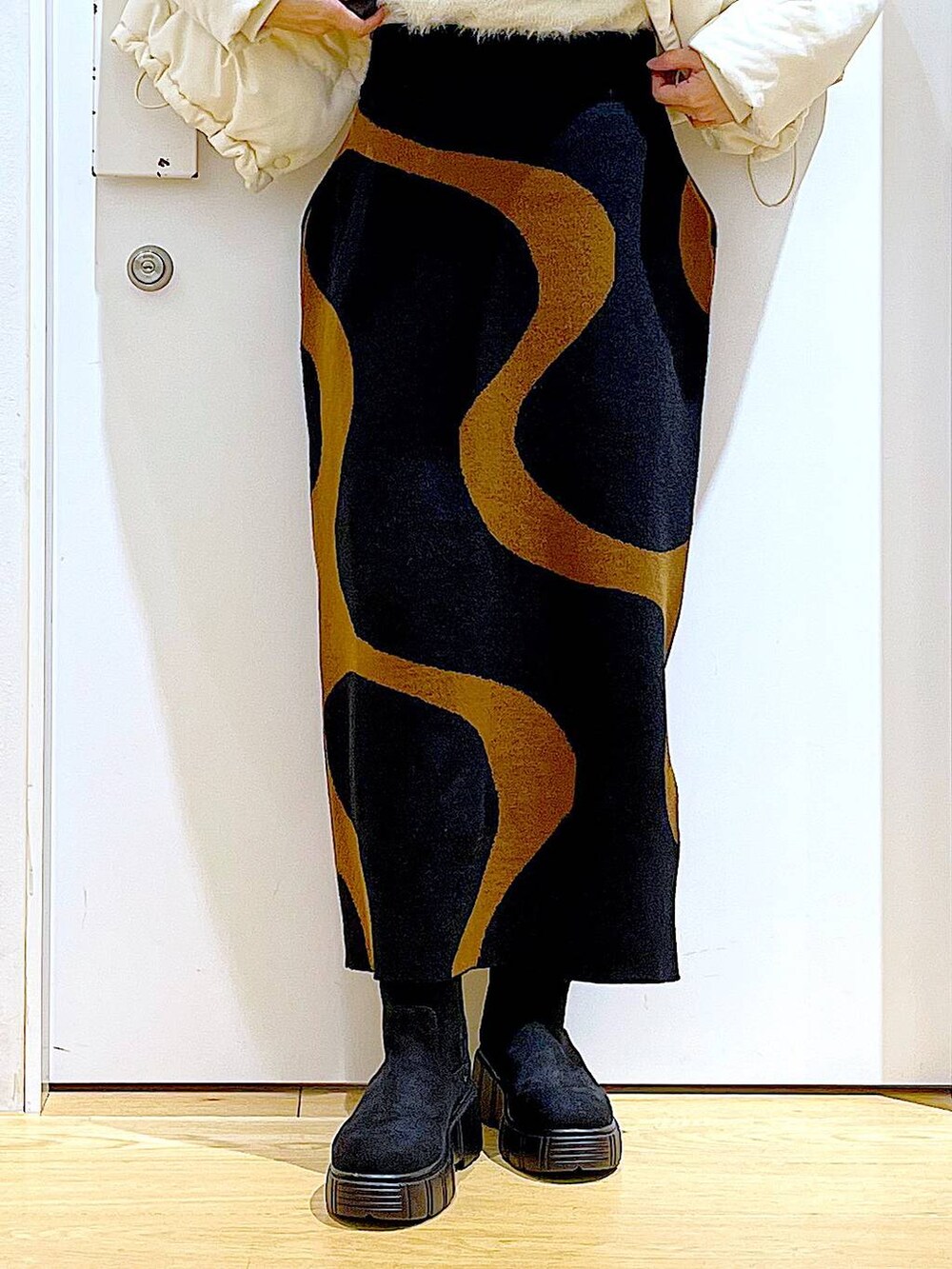 その他のスカート、ブラック系のショルダーバッグ、ブラック系のブーツを着用したレディースの冬コーディネートの8枚目の写真