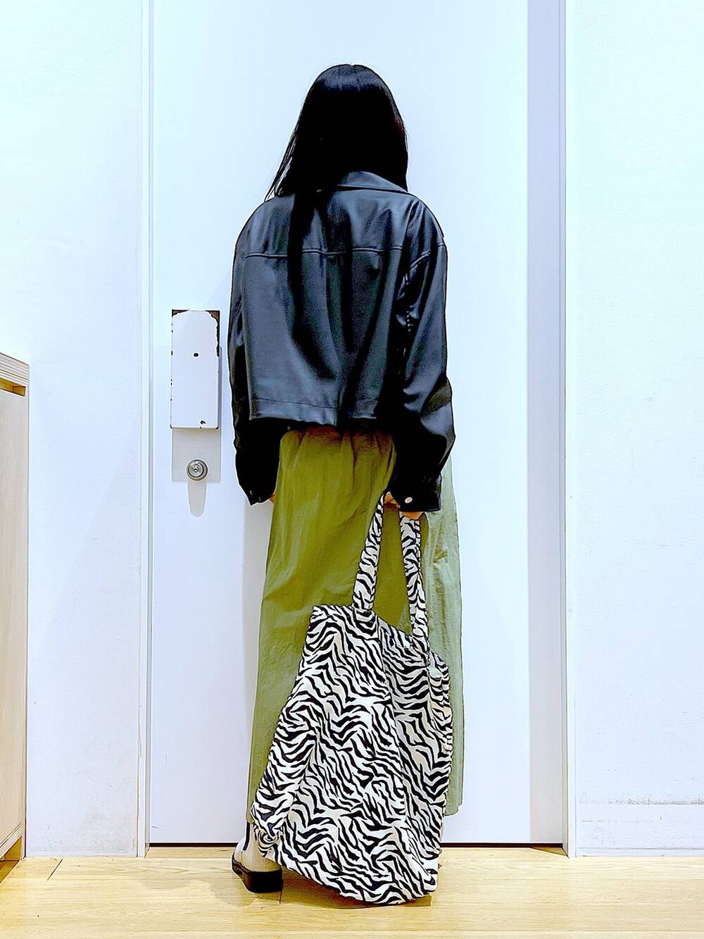 ブラック系のブルゾン、グレー系のスウェット、ベージュ系のブーツを着用したレディースの春コーディネートの5枚目の写真