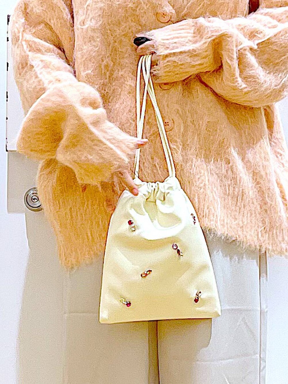 ピンク系のカーディガン/ボレロ、ホワイト系のショルダーバッグ、ホワイト系のTシャツ/カットソーを着用したレディースの冬コーディネートの9枚目の写真