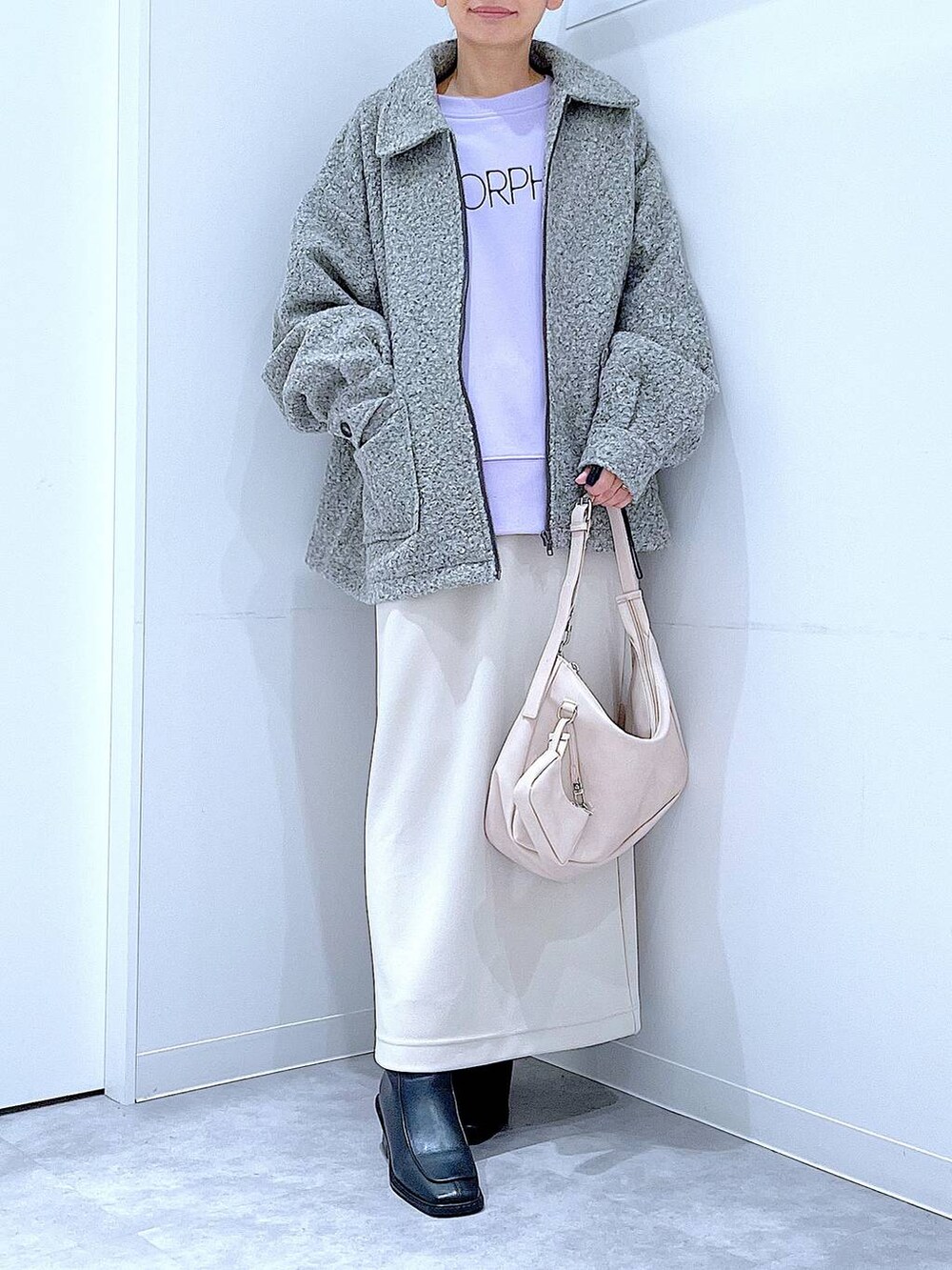 ベージュ系のスカート、グレー系のブルゾン、ブラック系のブーツを着用したレディースの秋コーディネートの6枚目の写真