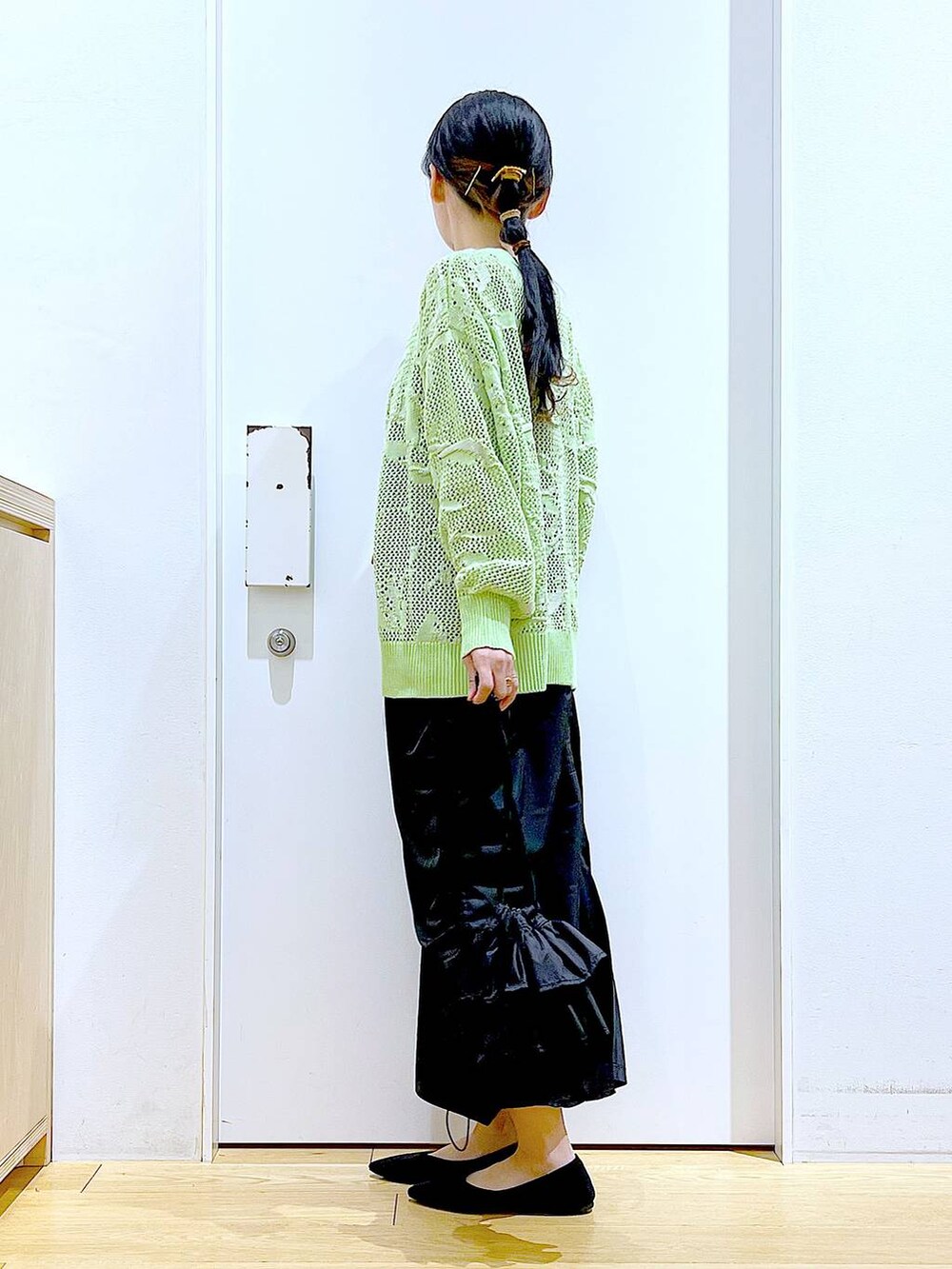 ブラック系のショルダーバッグ、ブラック系のパンプス、ブラック系のワンピースを着用したレディースの春コーディネートの3枚目の写真