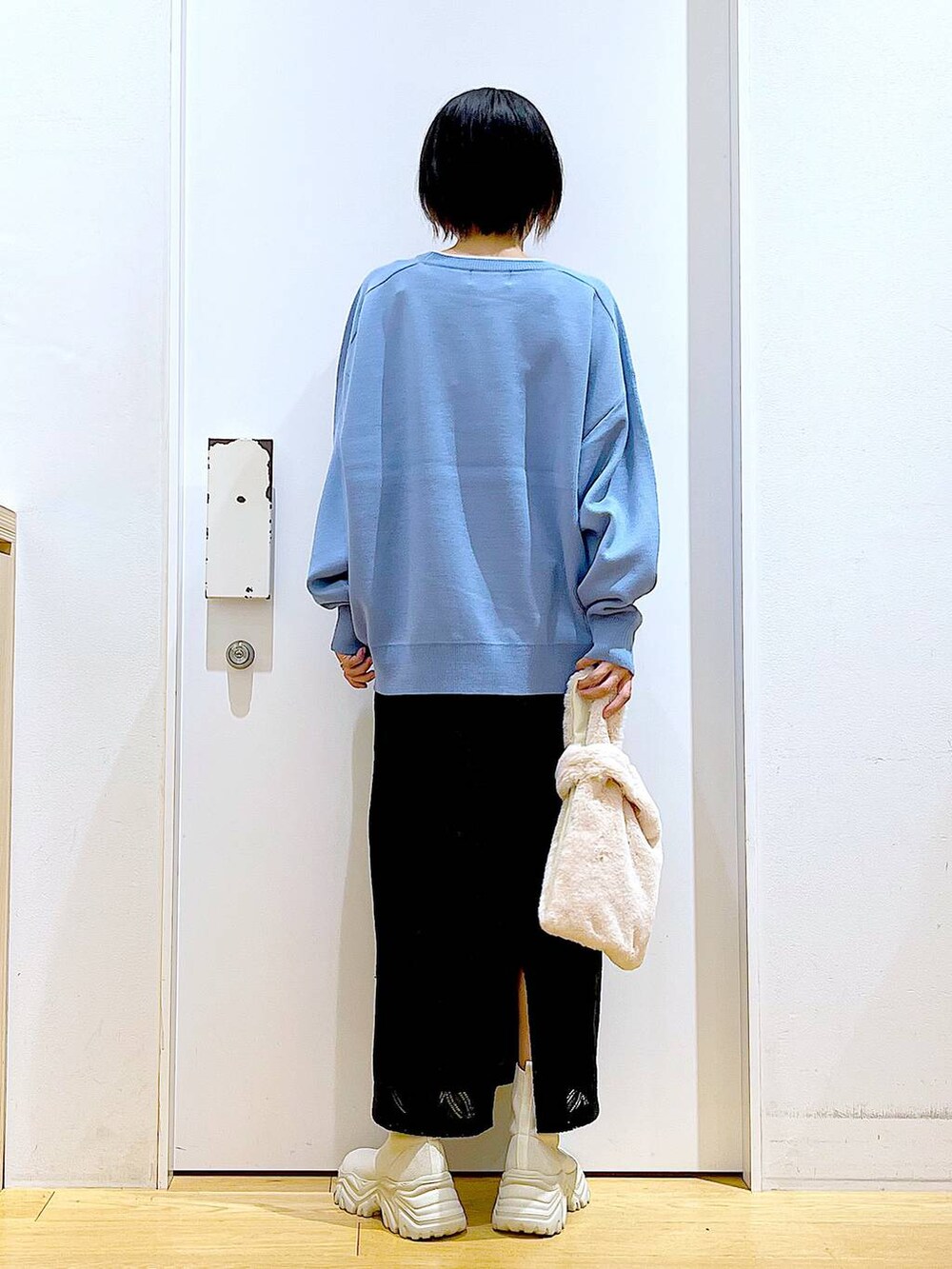 ブルー系のニット/セーター、ホワイト系のショルダーバッグ、ベージュ系のブーツを着用したレディースの冬コーディネートの5枚目の写真