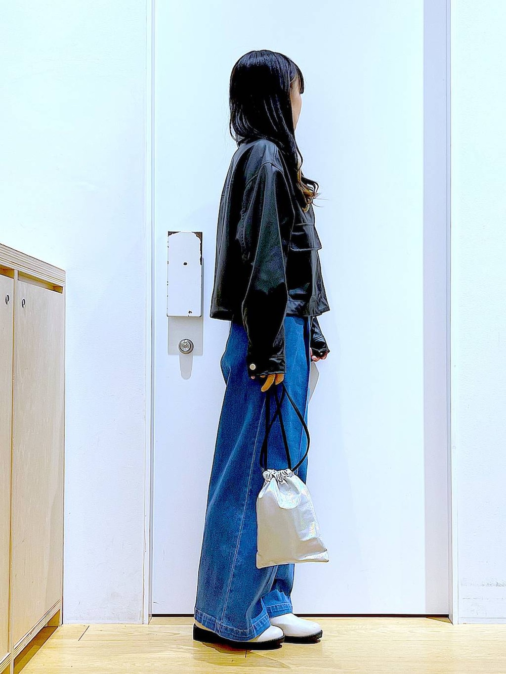 ブラック系のブルゾン、ブルー系のデニムパンツ、その他のニット/セーターを着用したレディースの冬コーディネートの4枚目の写真