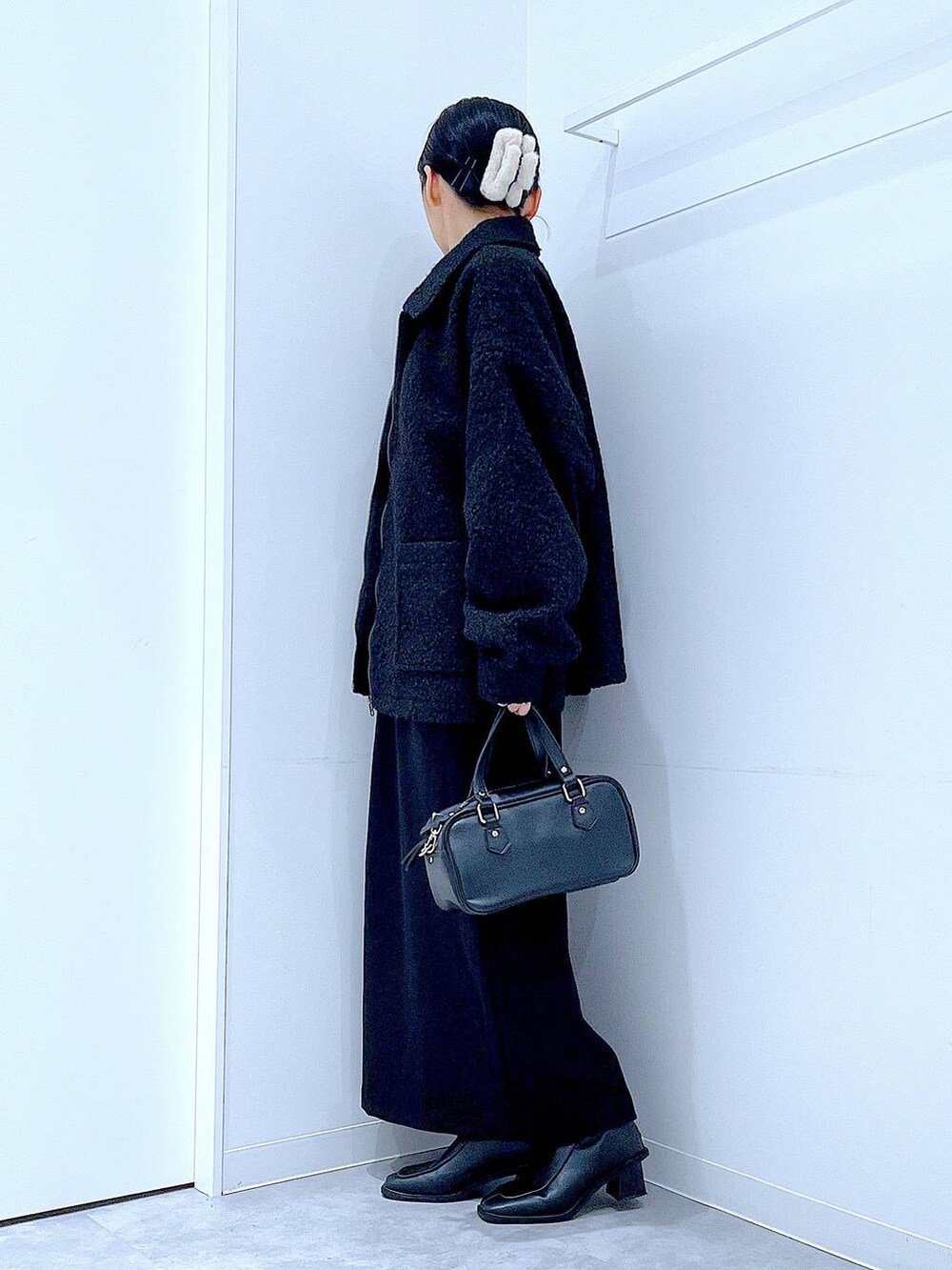 ブラック系のスカート、ブラック系のブルゾン、ブラック系のブーツを着用したレディースの冬コーディネートの4枚目の写真