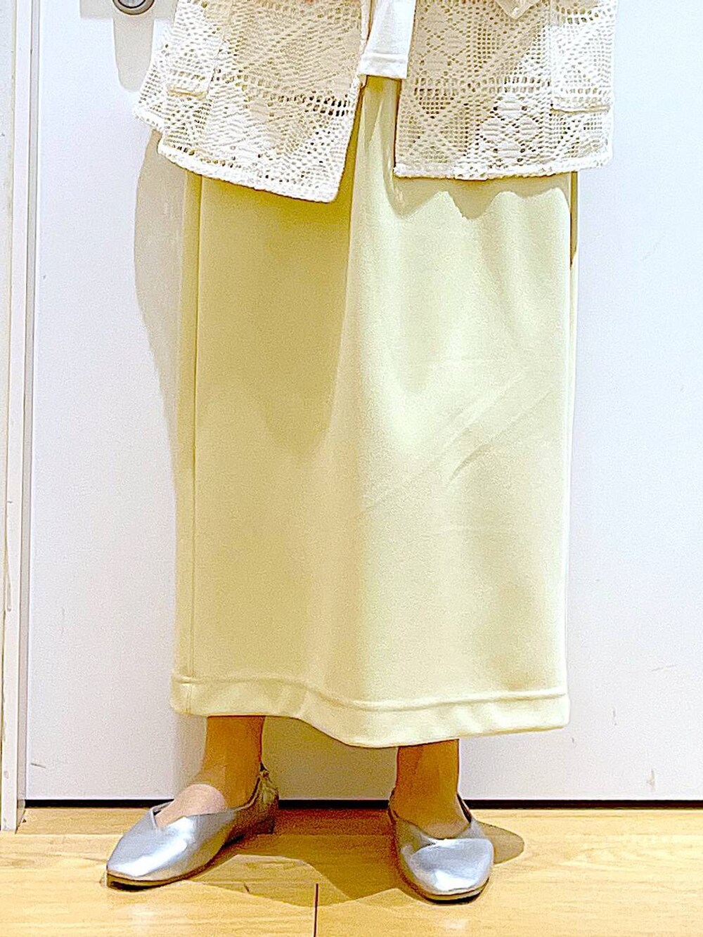 シルバー系のパンプス、ベージュ系のショルダーバッグ、イエロー系のスカートを着用したレディースの春コーディネートの8枚目の写真