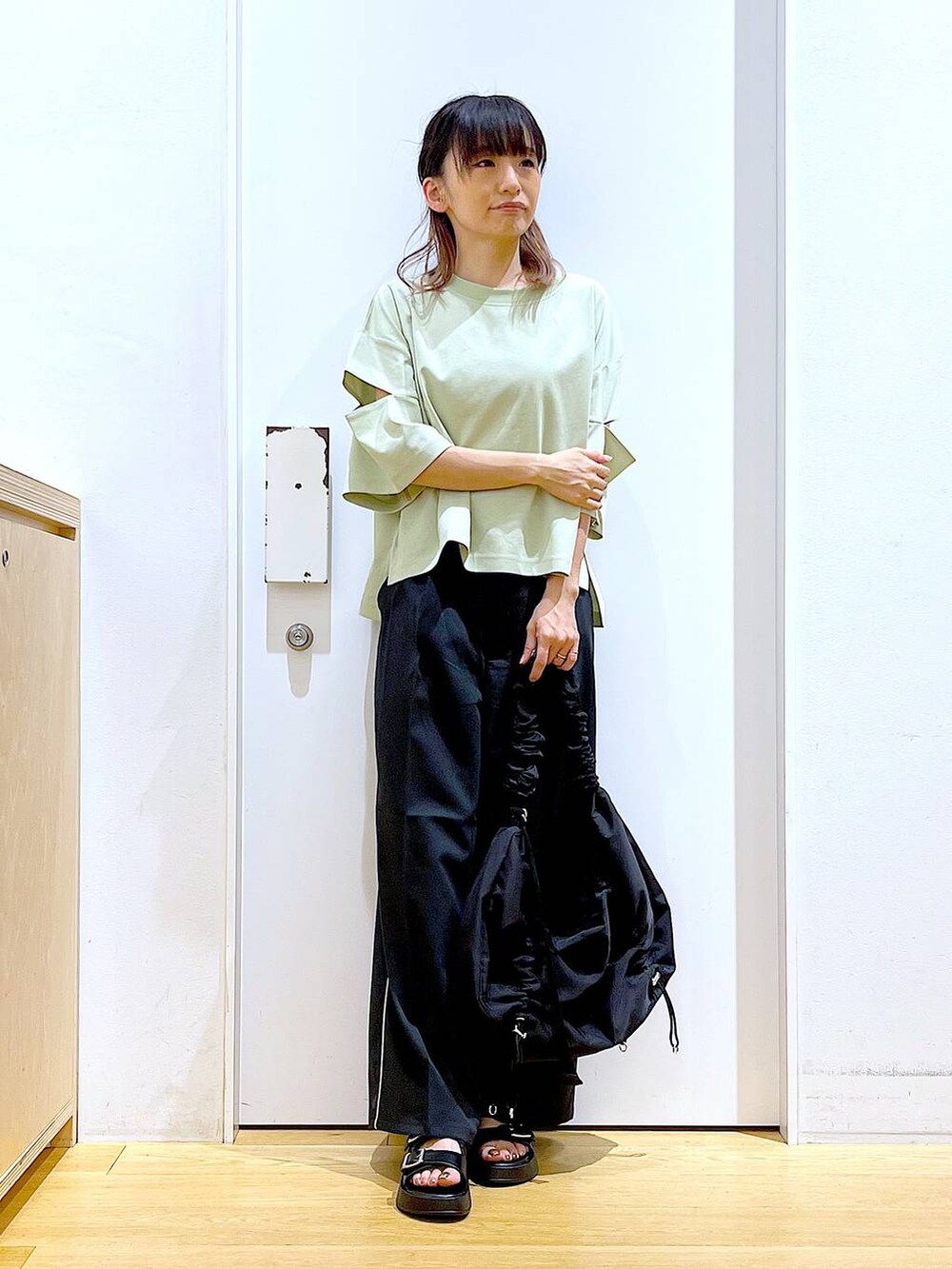 ブラック系のサンダル、ブラック系のショルダーバッグ、ブラック系のスラックスを着用したレディースの夏コーディネートの2枚目の写真