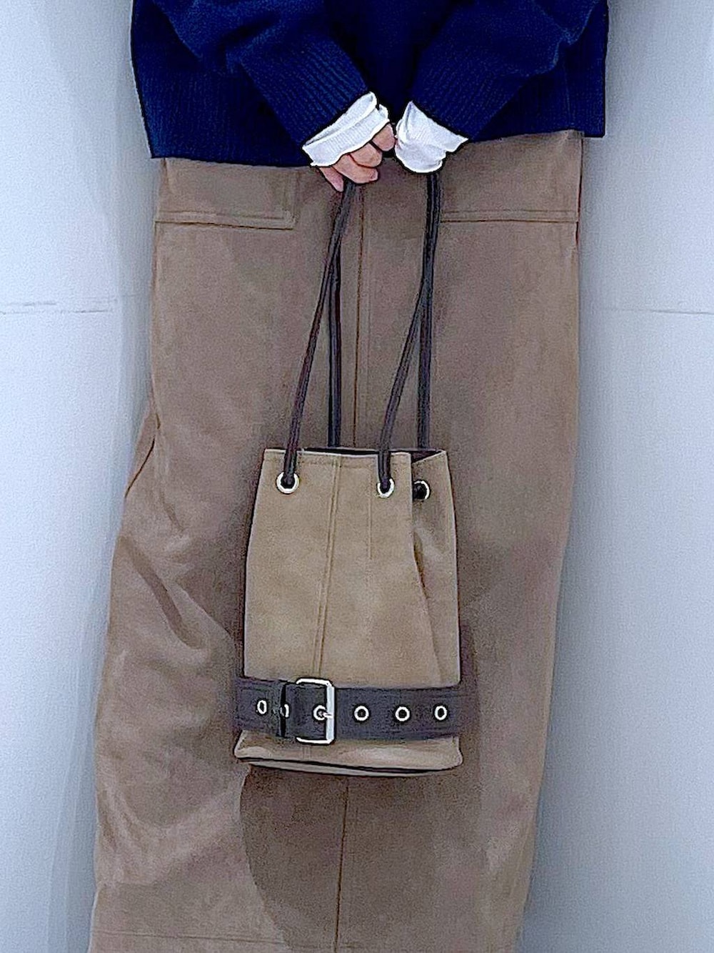 ブラック系のブーツ、ブラウン系のスカート、ベージュ系のハンドバッグを着用したレディースの冬コーディネートの9枚目の写真