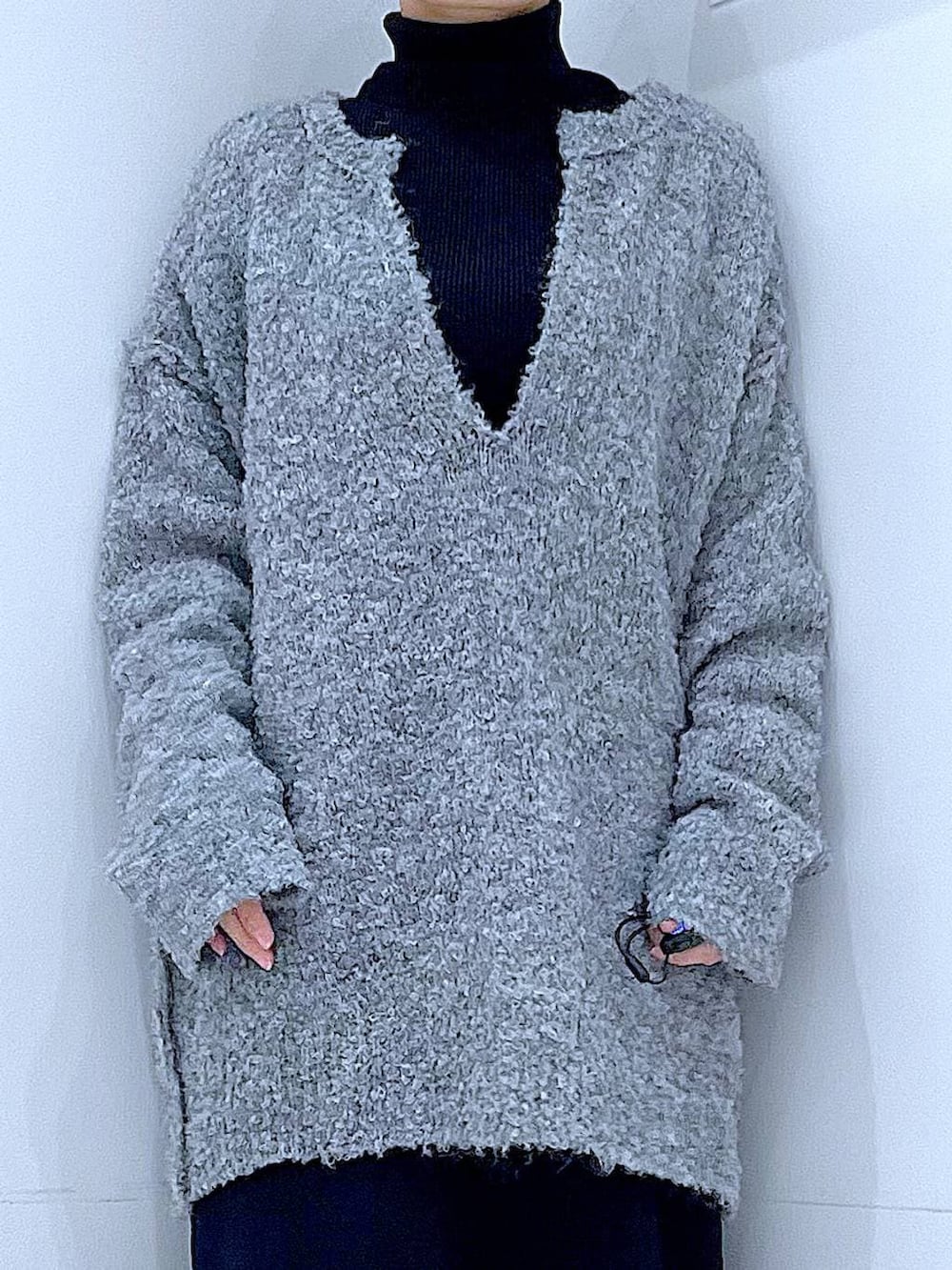 ブラック系のブーツ、グレー系のニット/セーター、ブラック系のスカートを着用したレディースの冬コーディネートの7枚目の写真