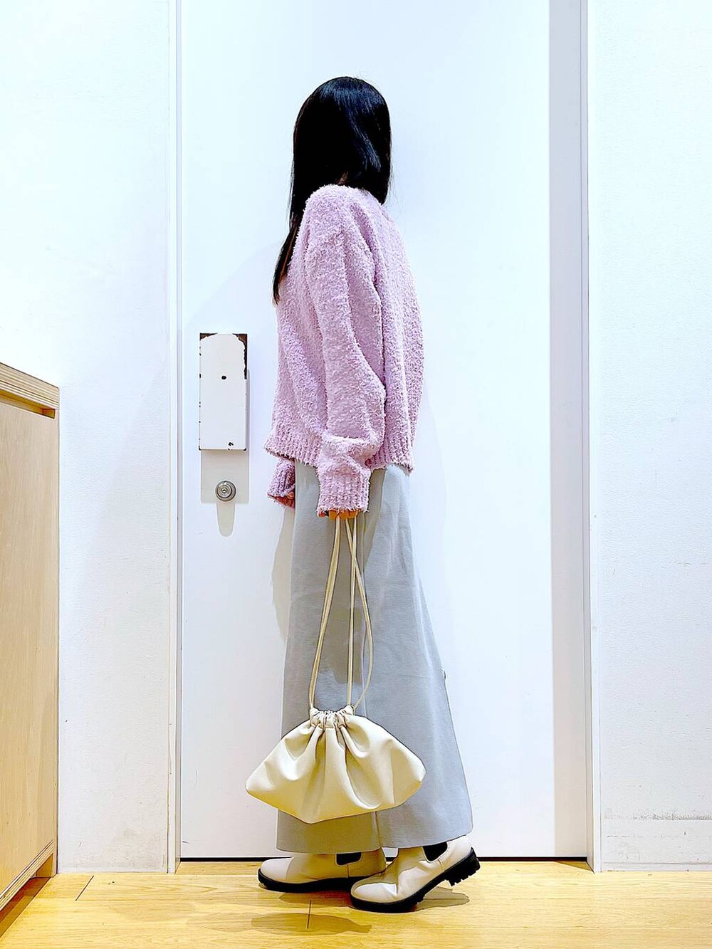 パープル系のニット/セーター、ベージュ系のブーツ、ベージュ系のショルダーバッグを着用したレディースの冬コーディネートの3枚目の写真