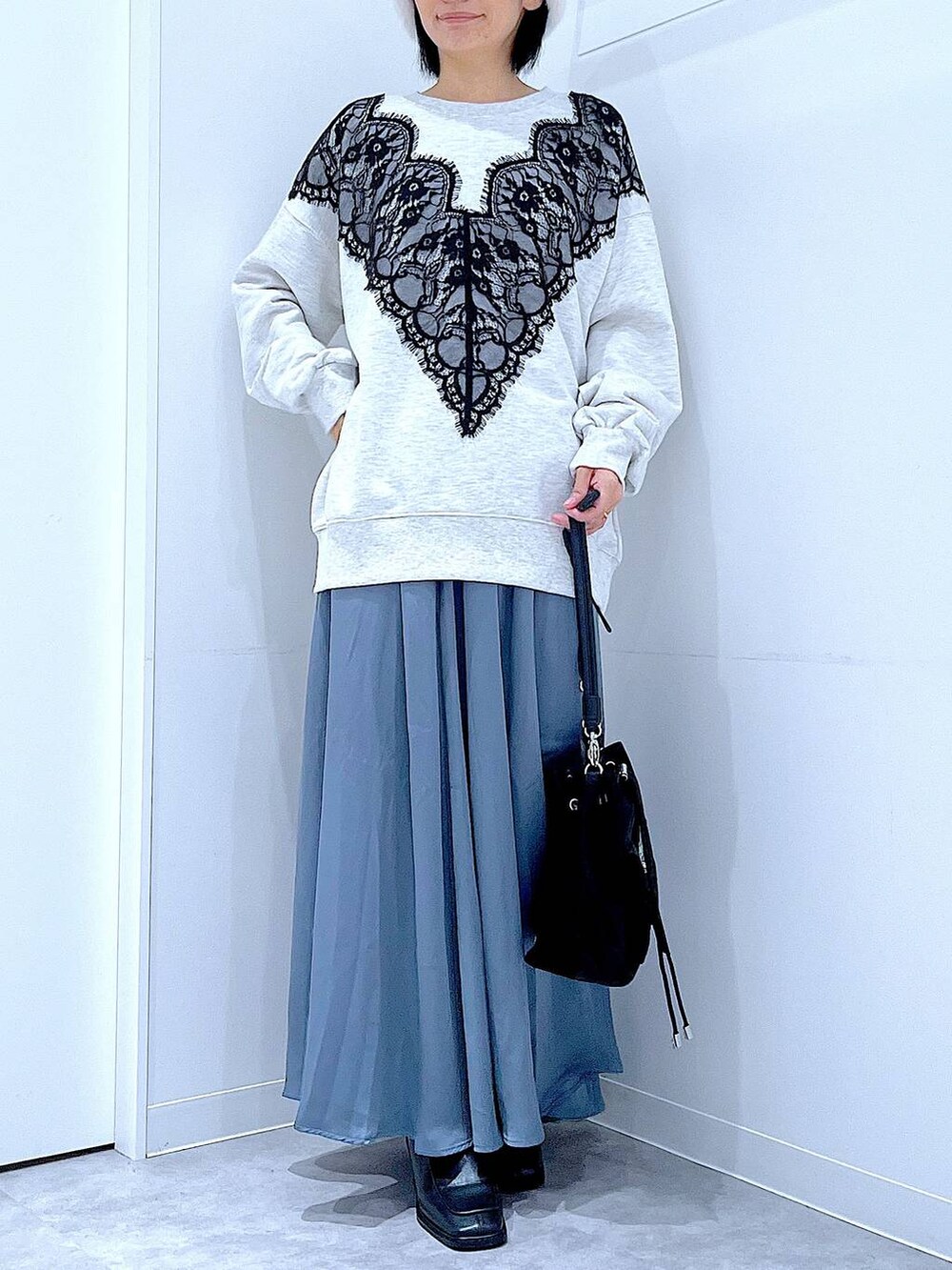 ブラック系のショルダーバッグ、ブラック系のブーツ、ベージュ系のスウェットを着用したレディースの冬コーディネートの6枚目の写真