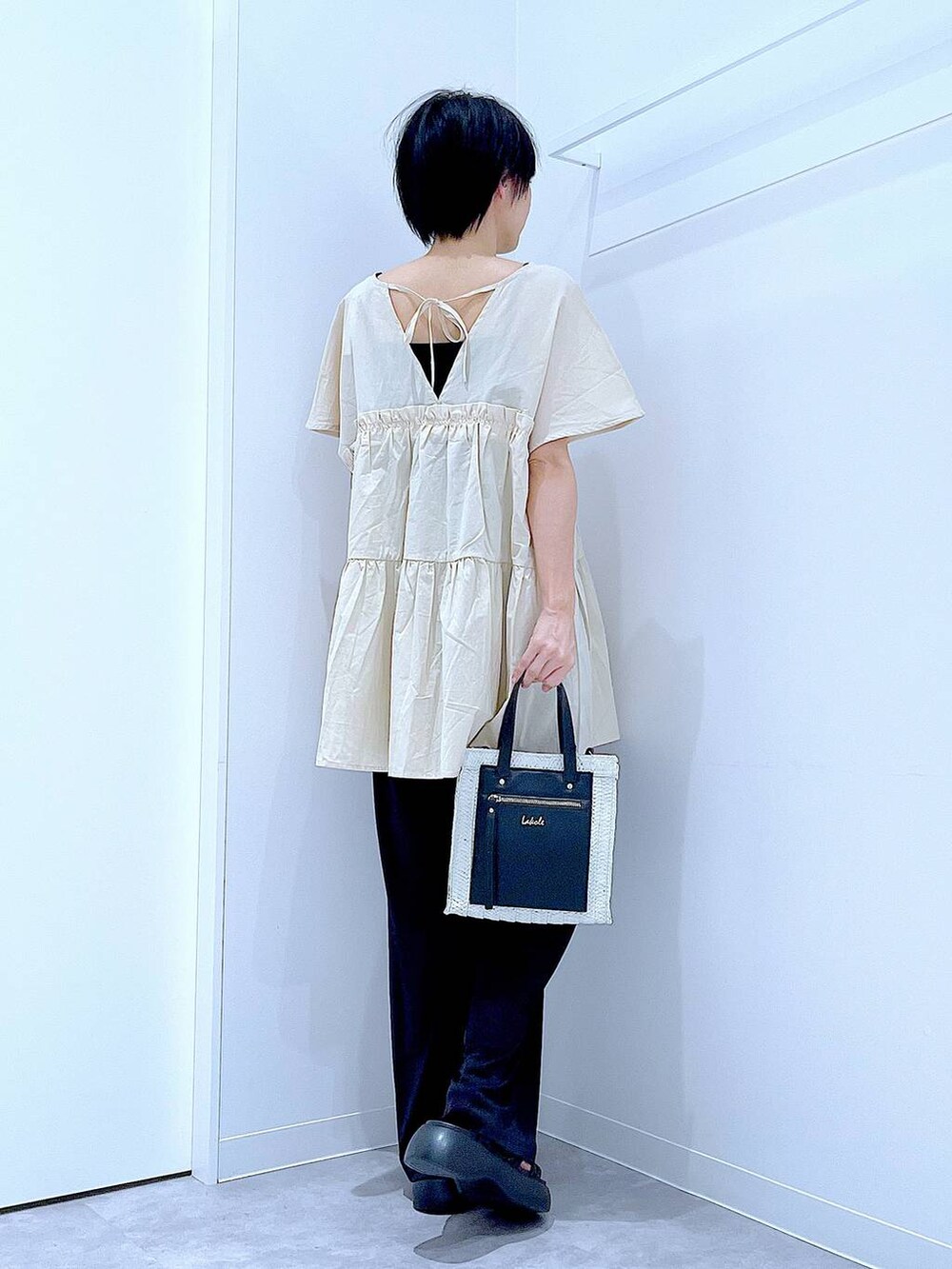 ホワイト系のショルダーバッグ、ブラック系のサンダル、ブラック系のその他パンツを着用したレディースの夏コーディネートの5枚目の写真