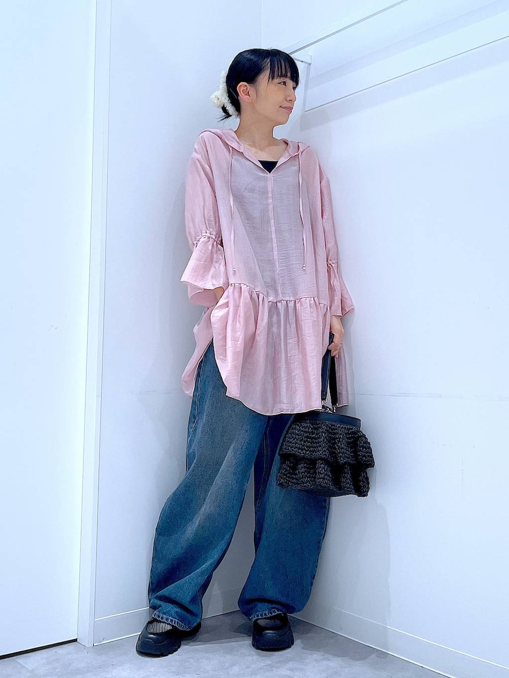 ブルー系のデニムパンツ、ブラック系のスニーカー、ブラック系のショルダーバッグを着用したレディースの春コーディネートの2枚目の写真