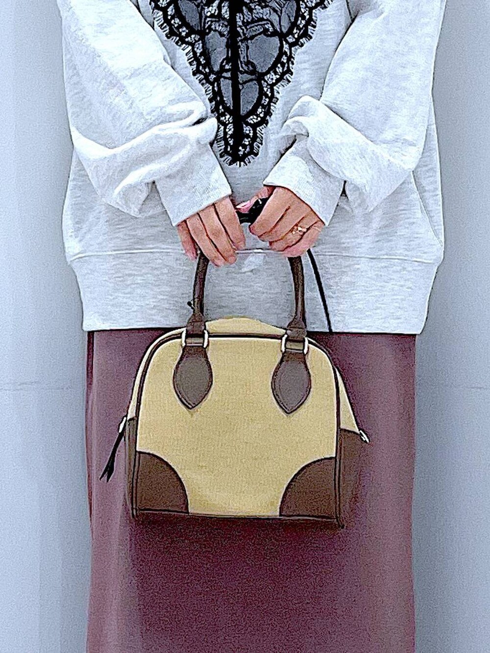 ベージュ系のハンドバッグ、ブラック系のブーツ、ベージュ系のスウェットを着用したレディースの秋コーディネートの9枚目の写真