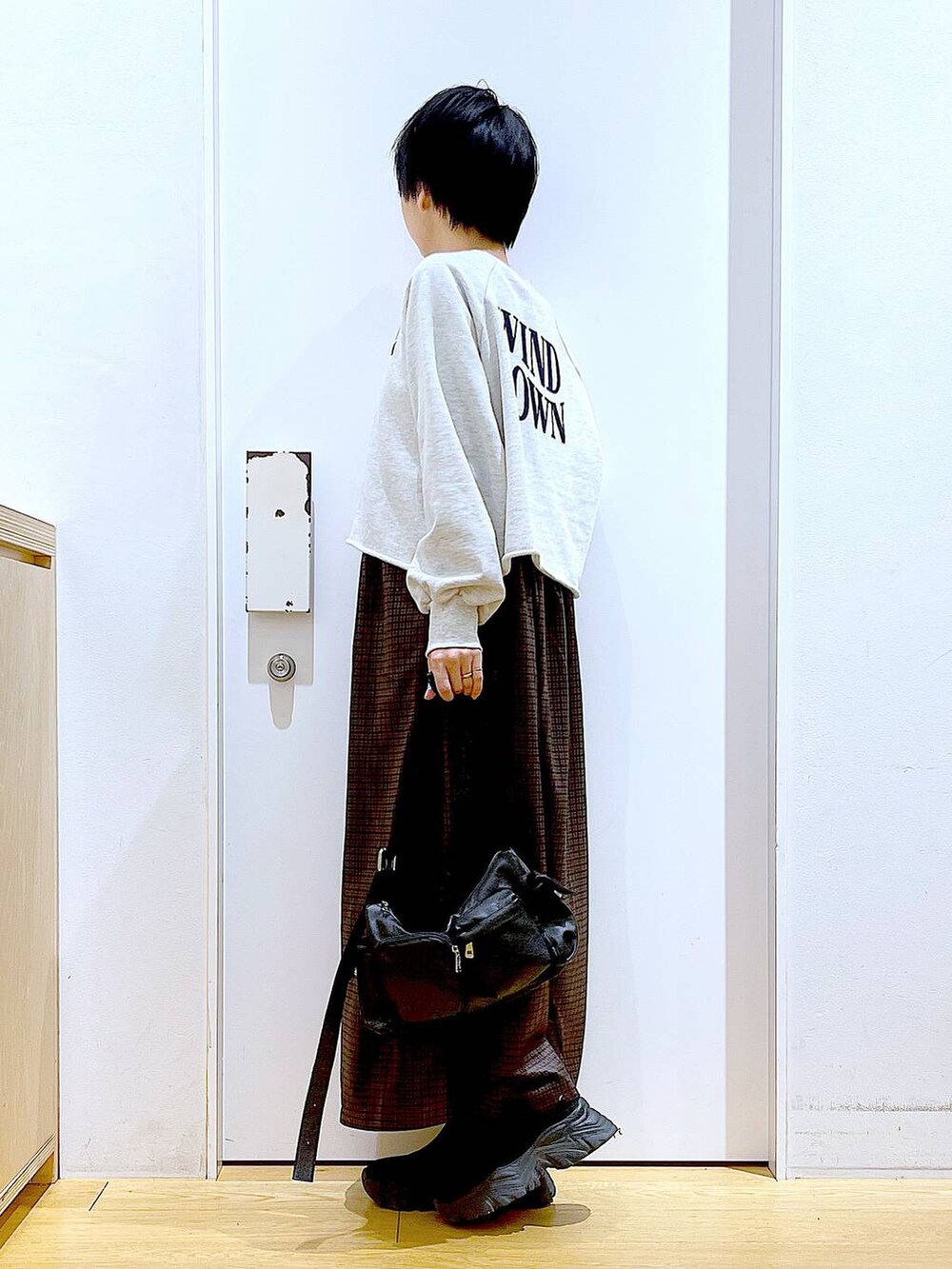 ブラック系のブーツ、ブラック系のショルダーバッグ、ブラウン系のワンピースを着用したレディースの冬コーディネートの3枚目の写真