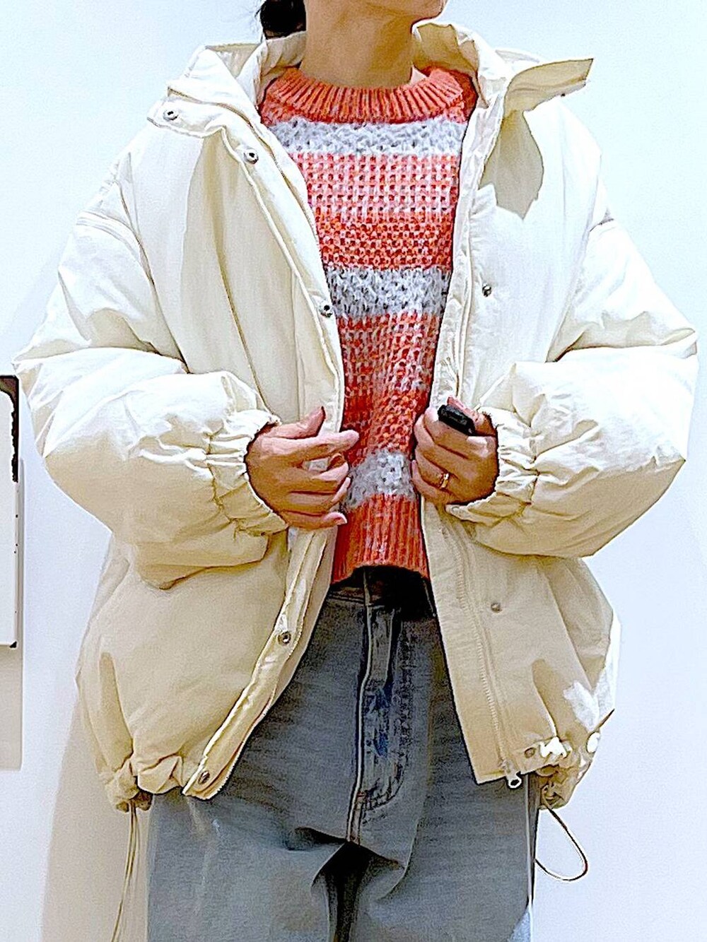 ブラック系のブーツ、ブルー系のデニムパンツ、シルバー系のショルダーバッグを着用したレディースの冬コーディネートの7枚目の写真