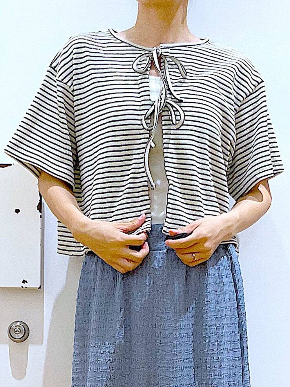 ホワイト系のサンダル、ブルー系のスカート、ホワイト系のショルダーバッグを着用したレディースの秋コーディネートの7枚目の写真