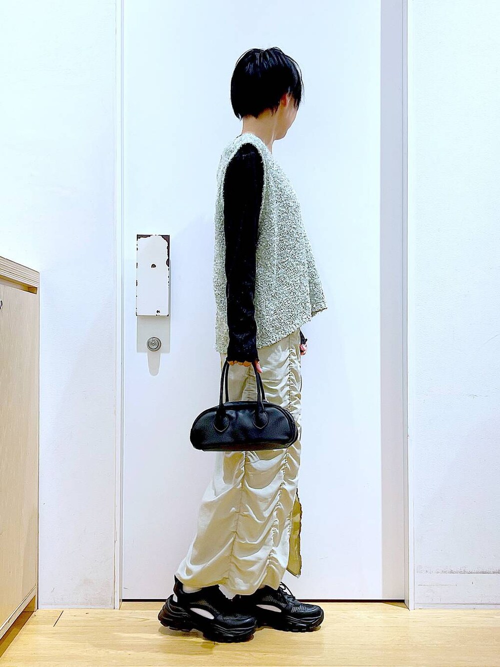 ベージュ系のスカート、ブラック系のボストンバッグ、ブラック系のTシャツ/カットソーを着用したレディースの春コーディネートの4枚目の写真