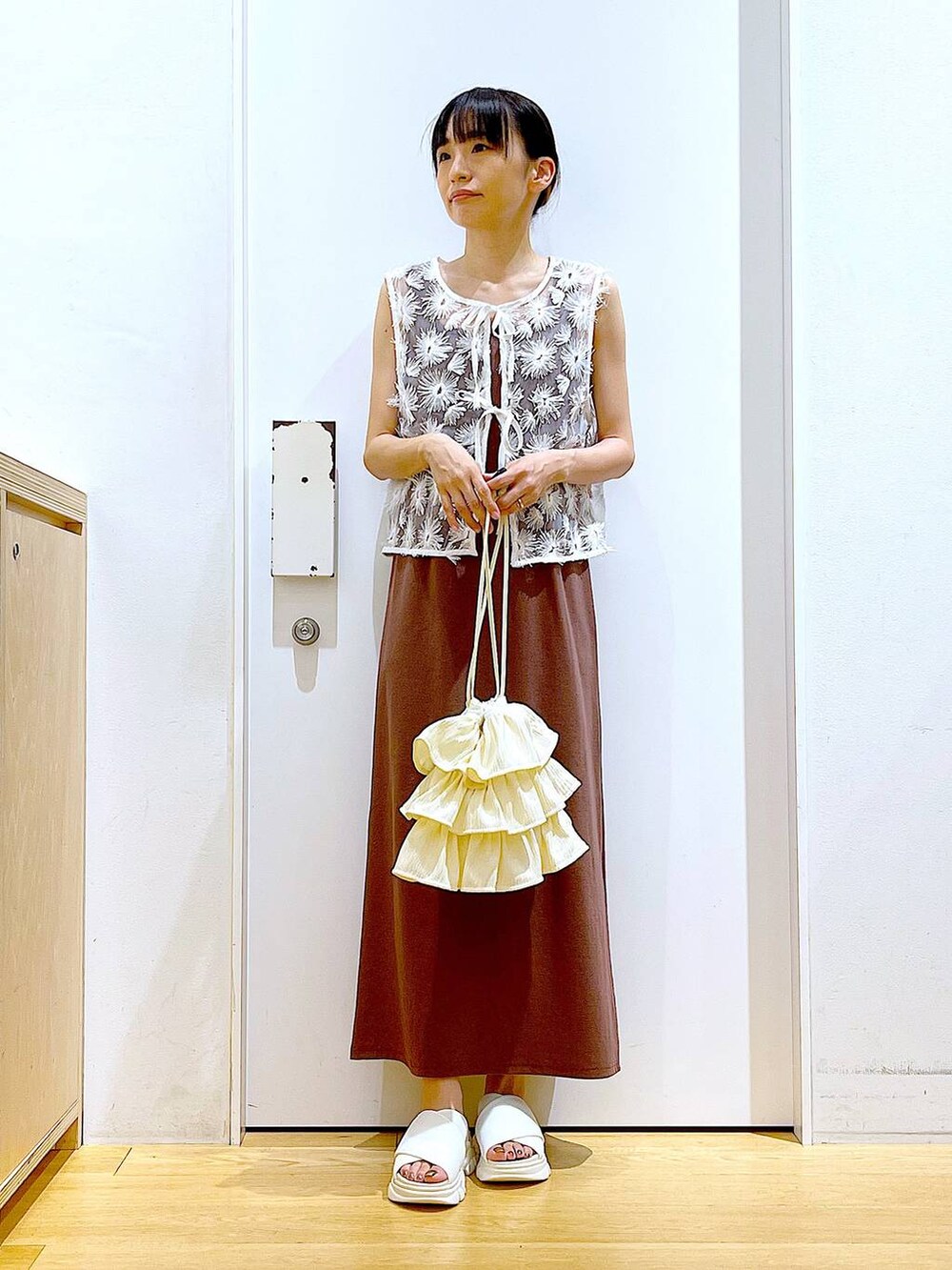 ホワイト系のサンダル、レッド系のワンピース、ホワイト系のベストを着用したレディースの夏コーディネートの2枚目の写真