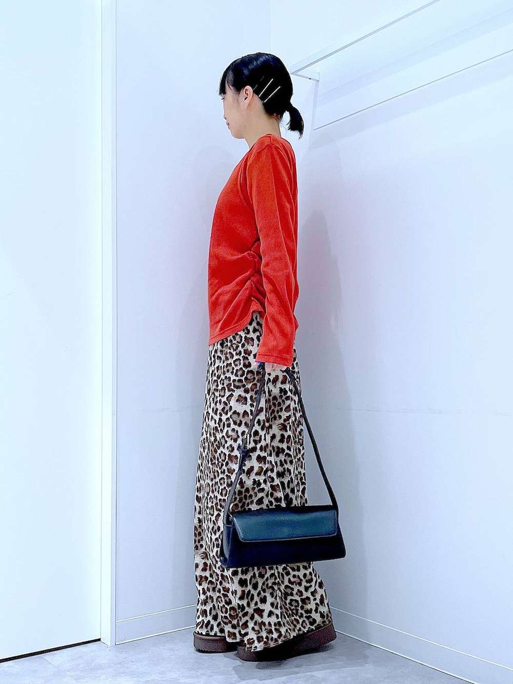 ブラック系のショルダーバッグ、ブラウン系のブーツ、ブラウン系のスカートを着用したレディースの秋コーディネートの3枚目の写真