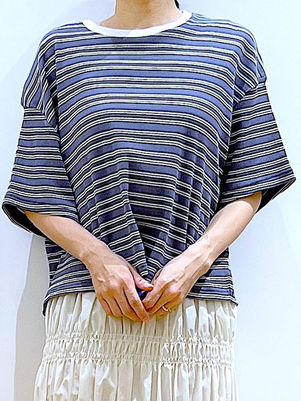 ホワイト系のショルダーバッグ、ホワイト系のサンダル、グレー系のTシャツ/カットソーを着用したレディースの夏コーディネートの7枚目の写真