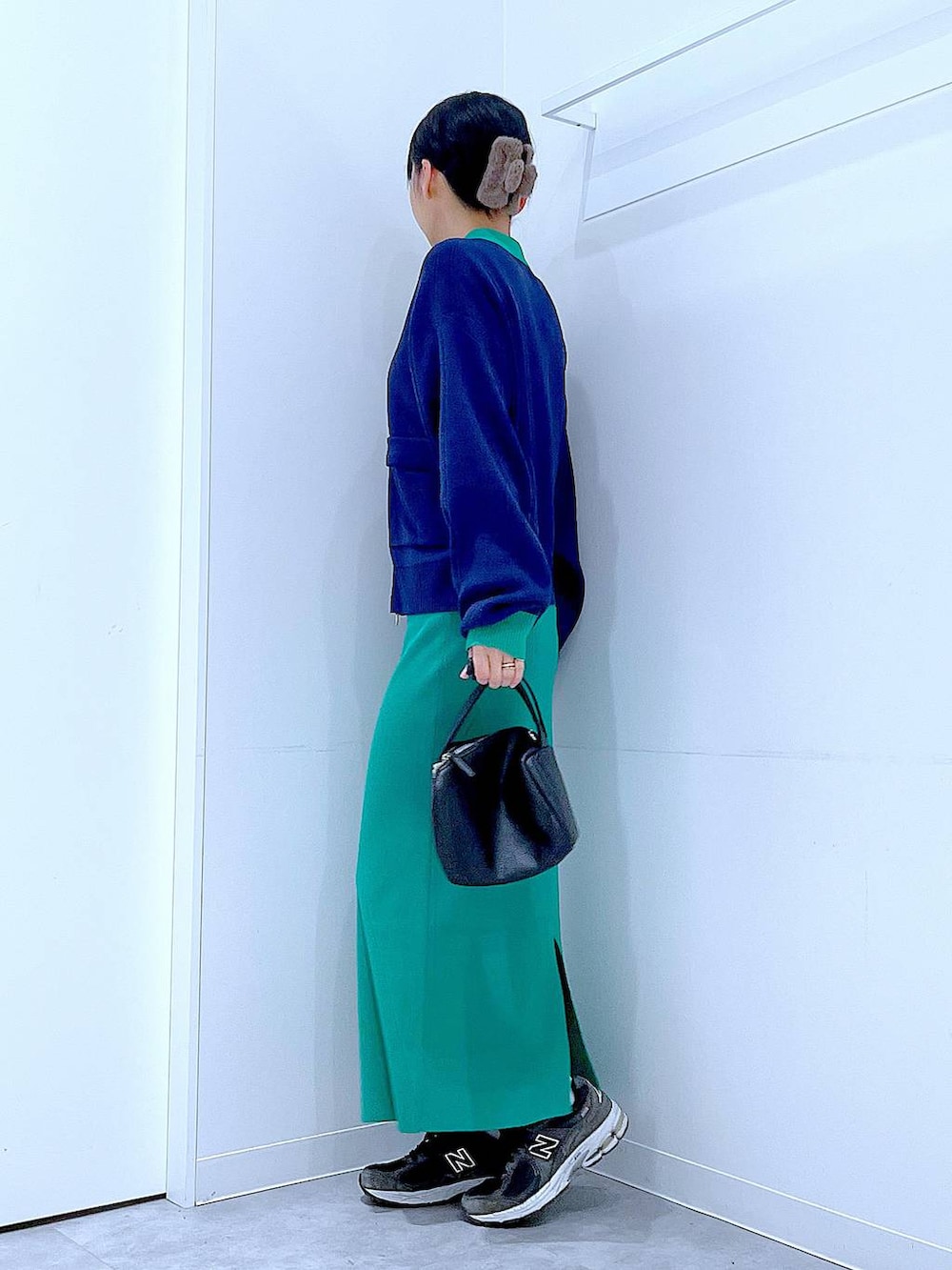 ブラック系のショルダーバッグ、ブルー系のカーディガン/ボレロ、グリーン系のスカートを着用したレディースの春コーディネートの3枚目の写真