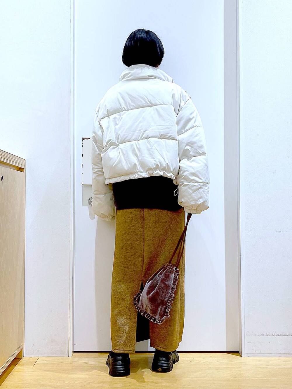 ベージュ系のブルゾン、ブラウン系のショルダーバッグ、ブラック系のブーツを着用したレディースの冬コーディネートの5枚目の写真