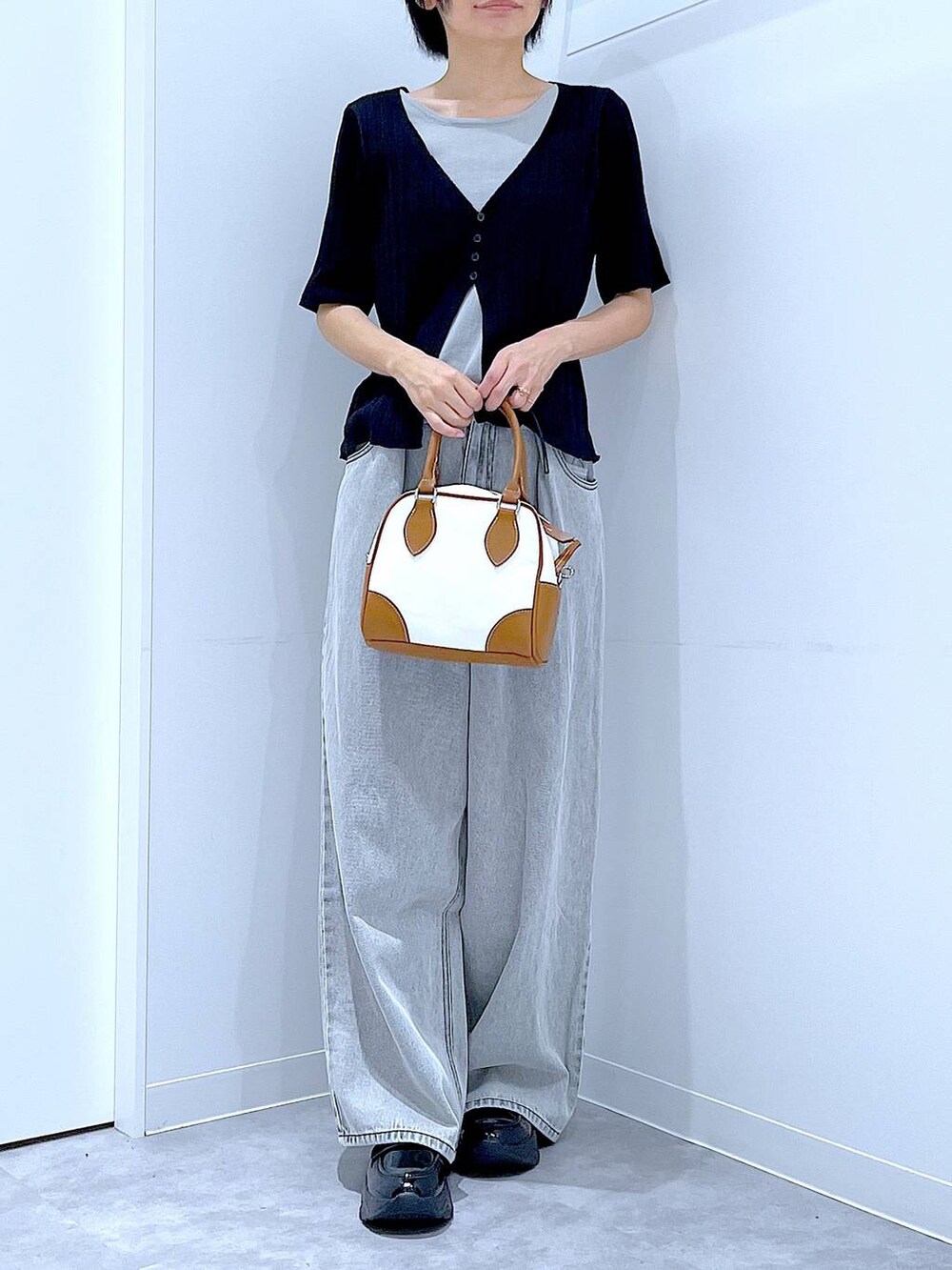 ブラック系のローファー、ホワイト系のハンドバッグ、ブラック系のニット/セーターを着用したレディースの秋コーディネートの6枚目の写真