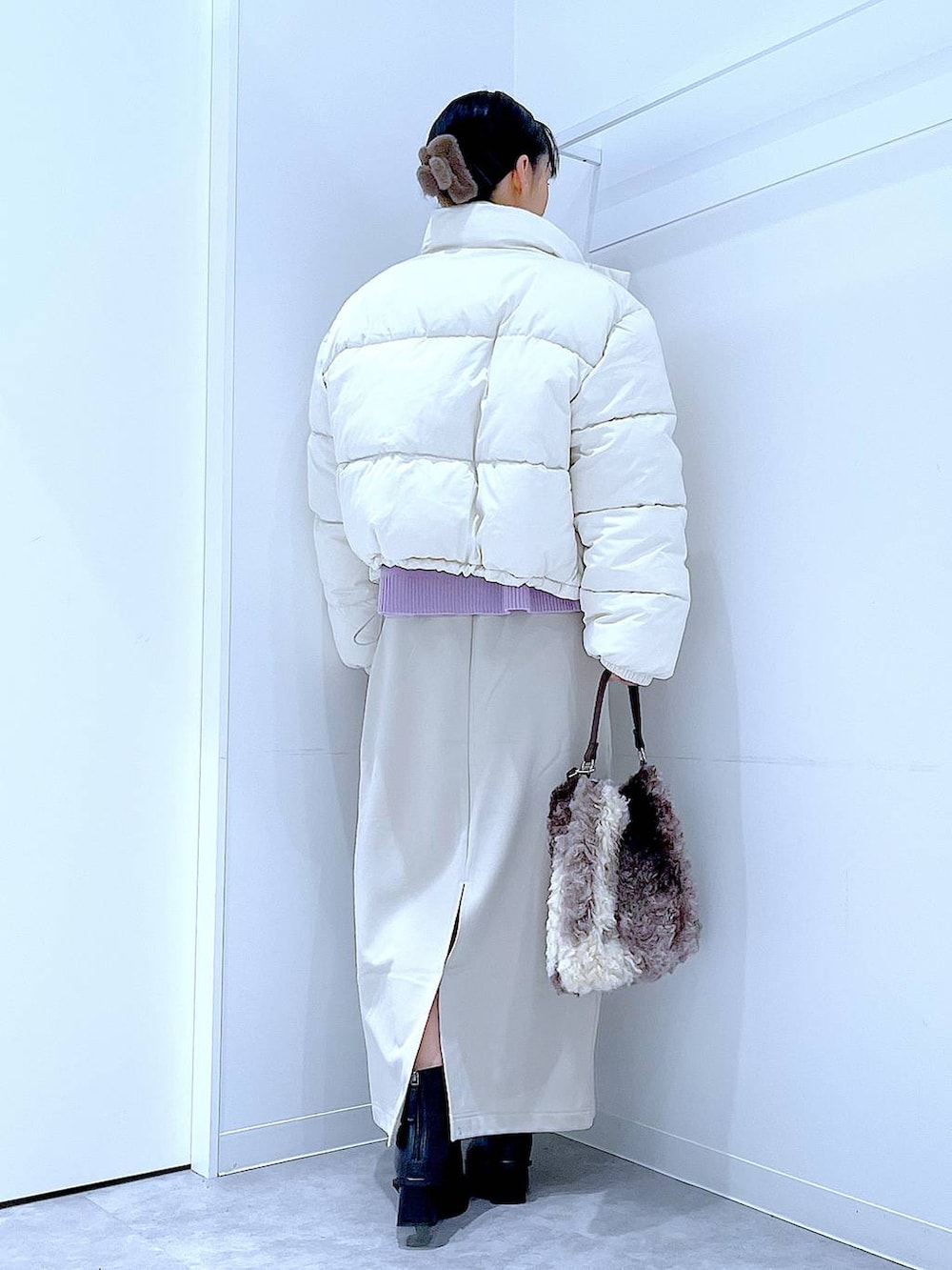 ホワイト系のブルゾン、ベージュ系のスカート、ブラック系のブーツを着用したレディースの冬コーディネートの5枚目の写真