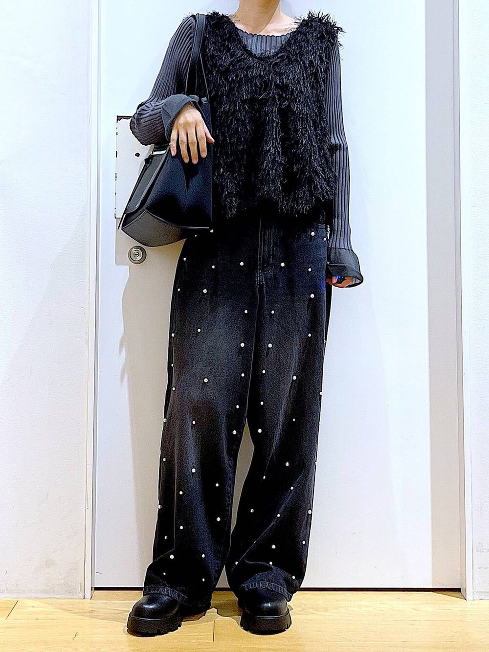 グレー系のニット/セーター、ブラック系のブーツ、ブラック系のトートバッグを着用したレディースの秋コーディネートの6枚目の写真