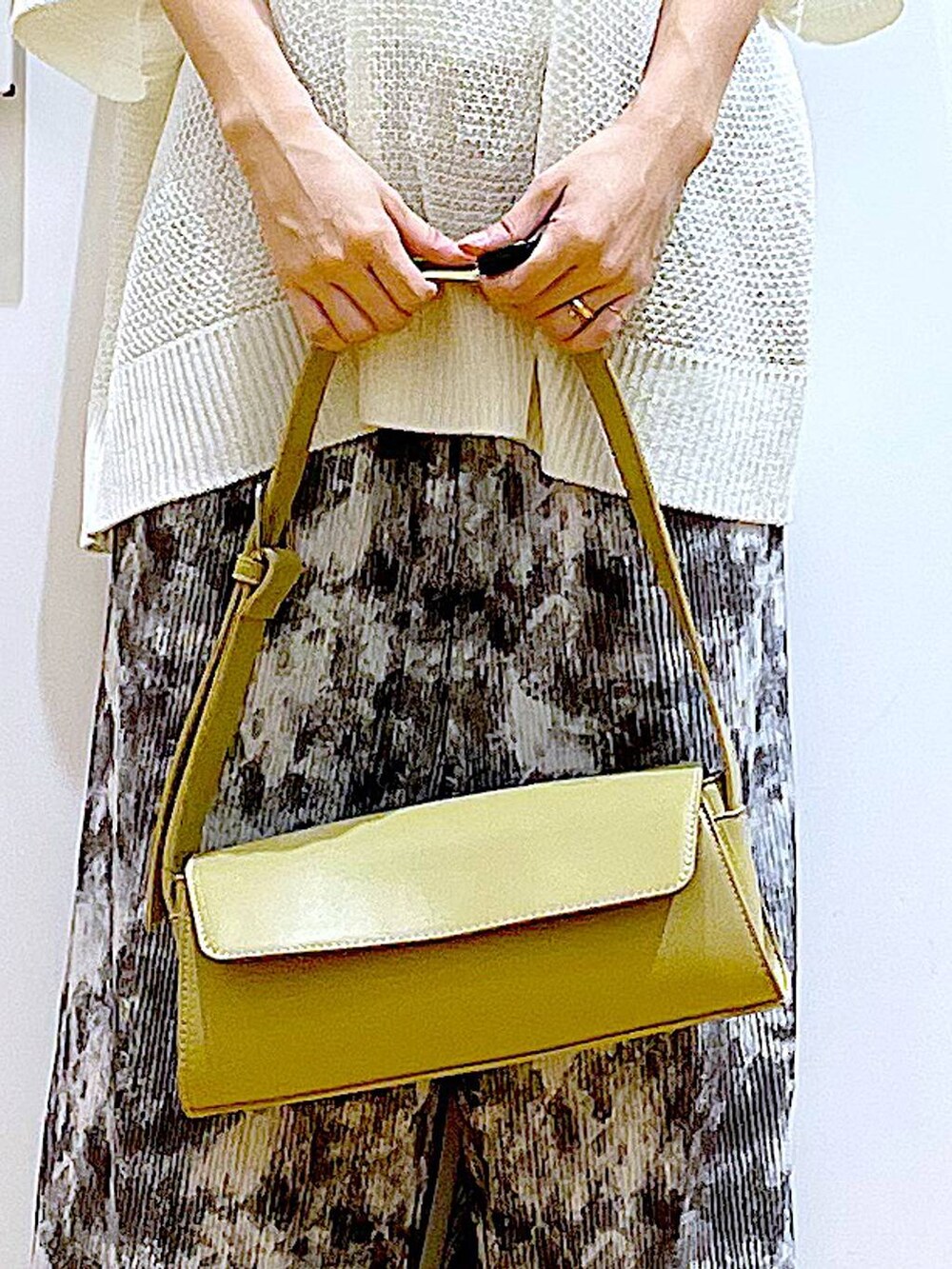 ベージュ系のパンプス、イエロー系のショルダーバッグ、グレー系のその他パンツを着用したレディースの春コーディネートの9枚目の写真