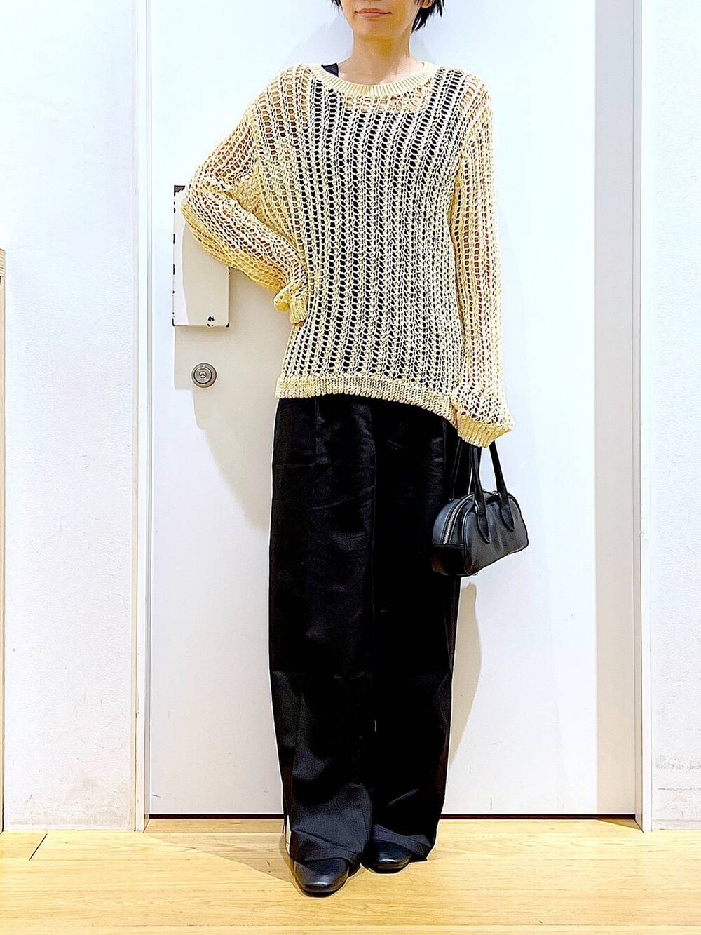 ブラック系のスラックス、ブラック系のボストンバッグ、ブラック系のパンプスを着用したレディースの夏コーディネートの6枚目の写真