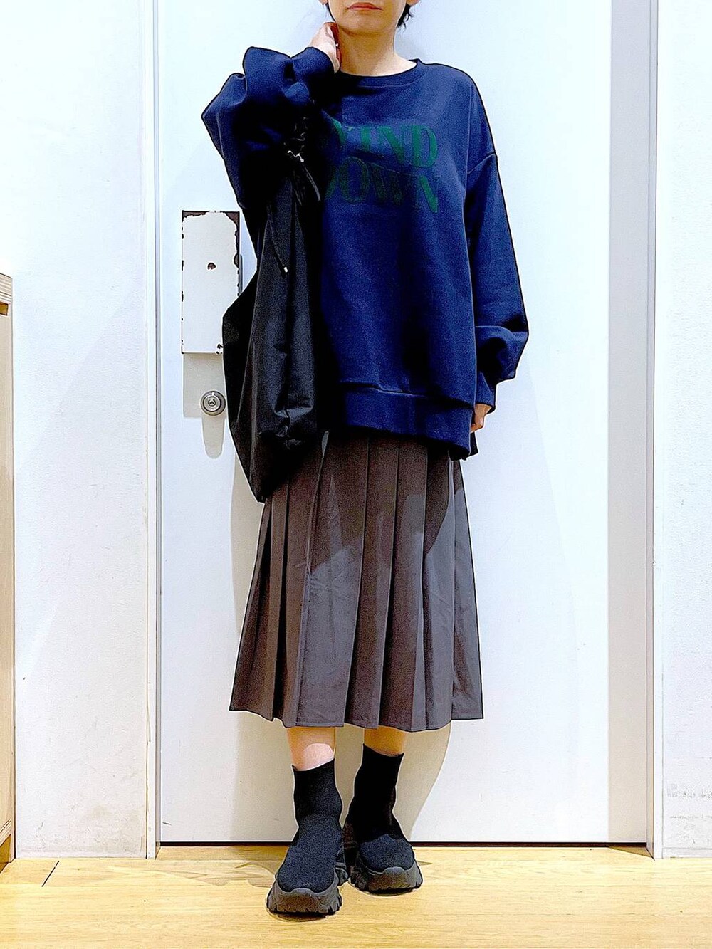 ブラック系のショルダーバッグ、ブラック系のブーツ、グレー系のスカートを着用したレディースの冬コーディネートの6枚目の写真