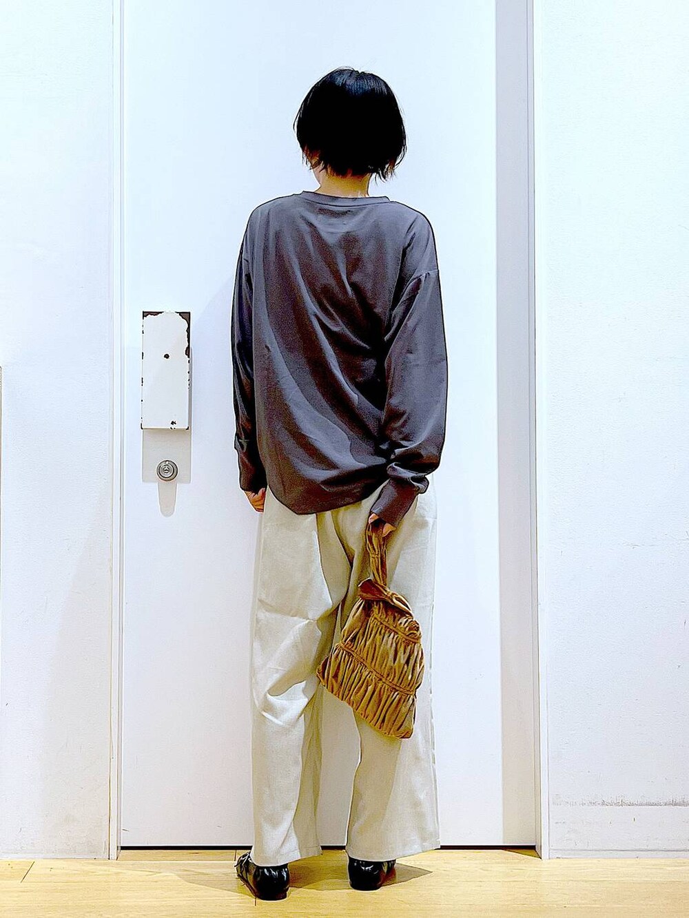 ブラック系のパンプス、イエロー系のショルダーバッグ、ベージュ系のその他パンツを着用したレディースの秋コーディネートの5枚目の写真