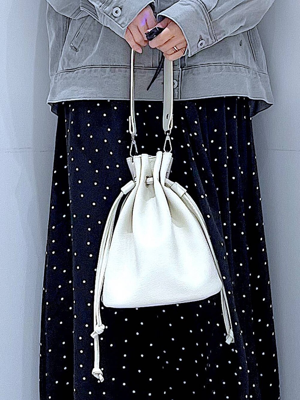 グレー系のデニムジャケット、ホワイト系のショルダーバッグ、グレー系のシュシュを着用したレディースの春コーディネートの9枚目の写真