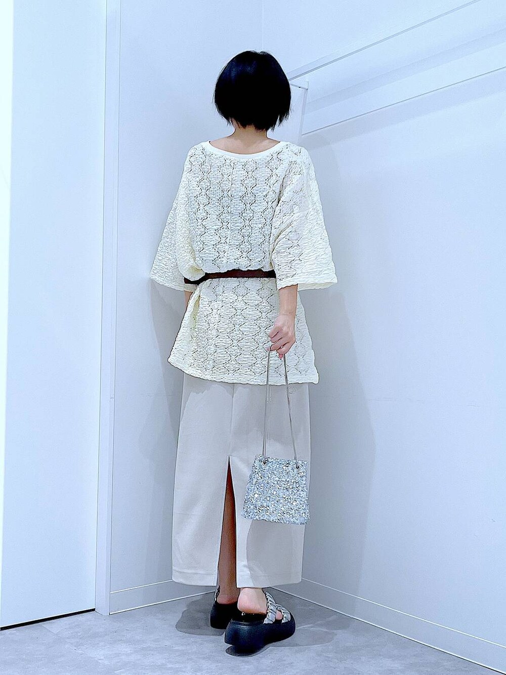 シルバー系のサンダル、ベージュ系のスカート、シルバー系のショルダーバッグを着用したレディースの夏コーディネートの5枚目の写真